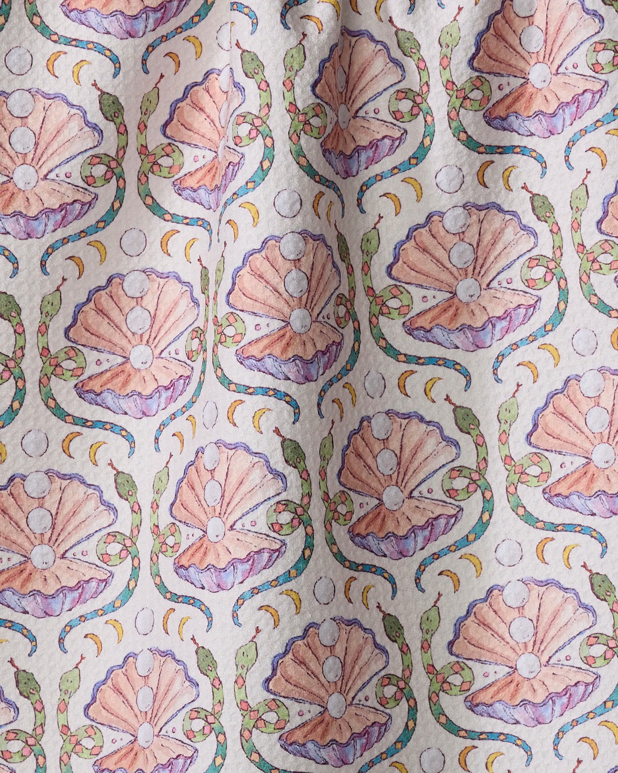 Pearls Of The Moon by Maayan Alper-Swan: an eco-friendly tea towel with pink seashells, green snakes, and colorful crescent moons on a light background—crafted from recycled materials.
