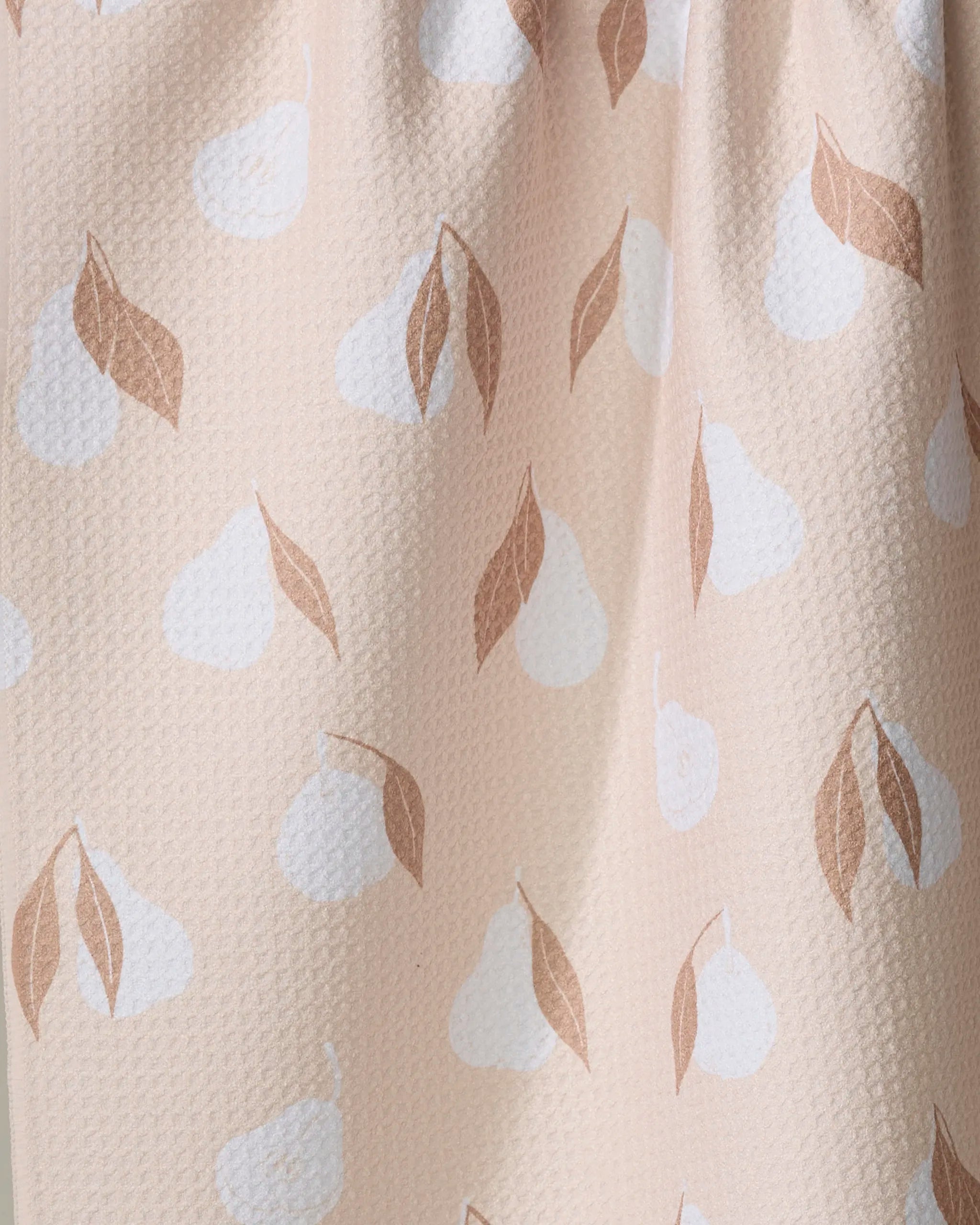 A close-up of the Pears Kitchen Tea Towel by Hufton Studio, featuring light pink Geoweave fabric with white pear shapes and brown leaves for a soft, subtle fruit-themed design.