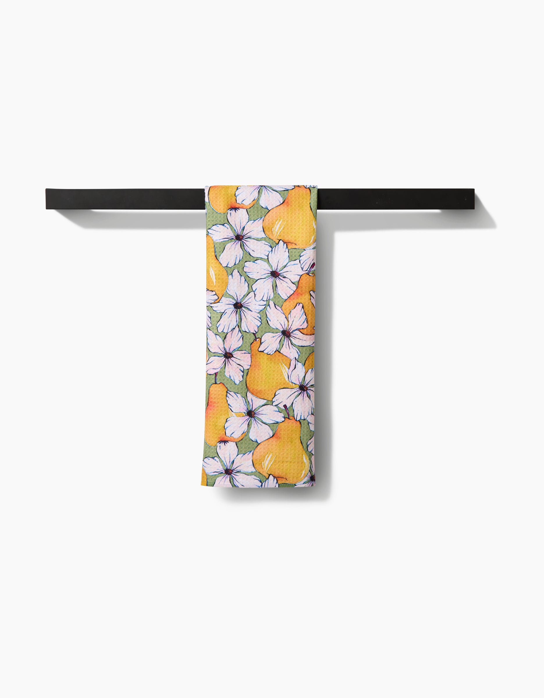 The Pears Petals tea towel by Maayan Alper-Swan features a vibrant yellow pear and white flower design on soft Geoweave fabric, neatly displayed over a black bar with a clean white background for style and durability.