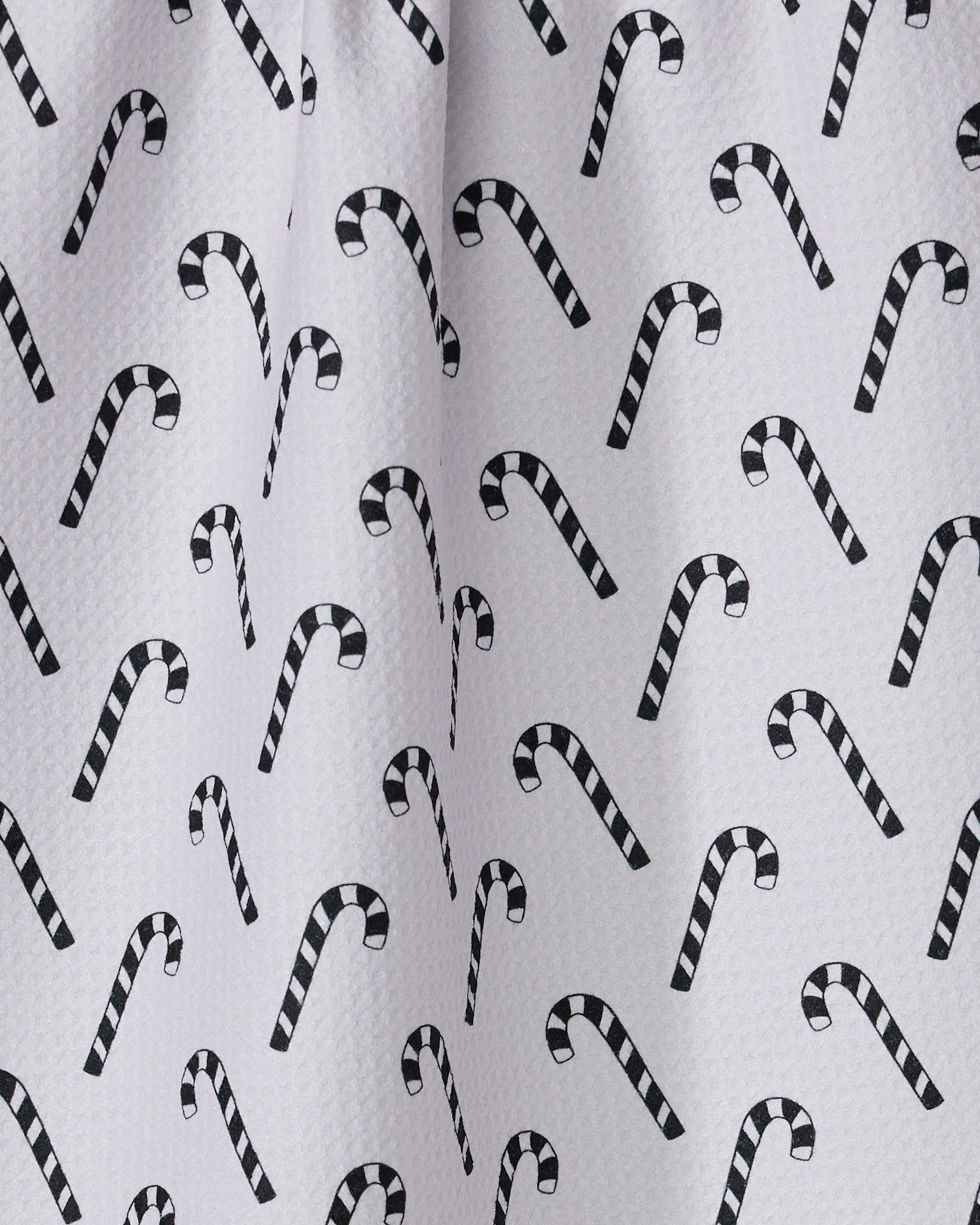 The Peppermint Pop kitchen towel by Geometry features a playful, festive black-and-white candy cane pattern on white recycled fabric with a textured surface for added charm.