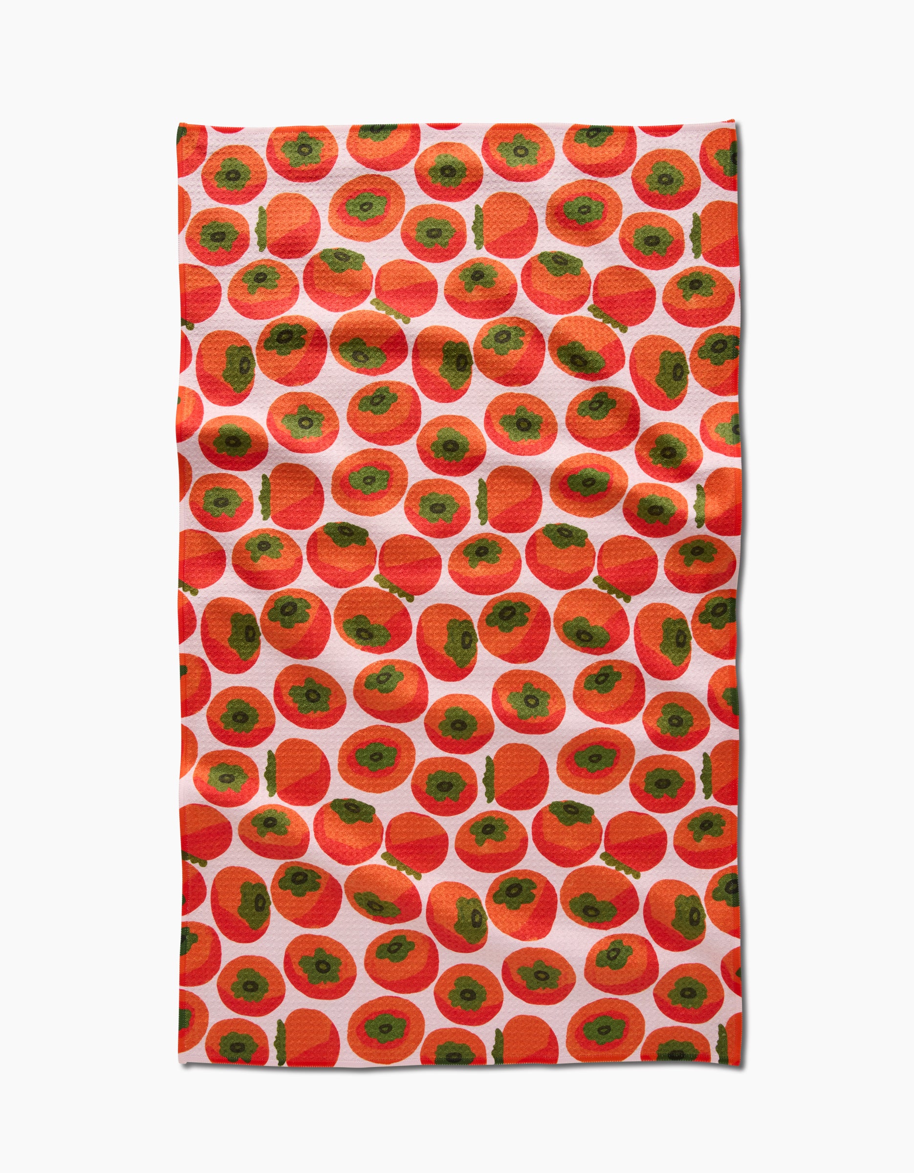 A rectangular kitchen tea towel by Katie OShea, called Persimmons, made from Geoweave fabric and featuring a vibrant, playful design of evenly spaced red and green persimmons on a white background.