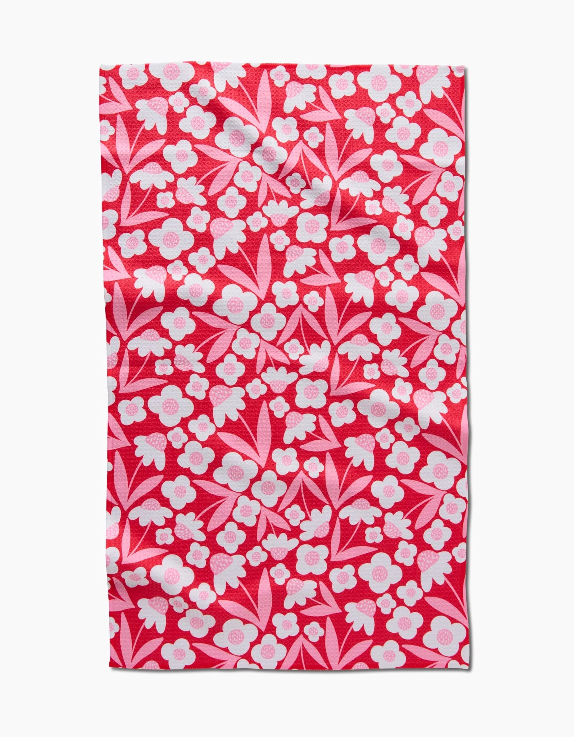 The Pink Blooms tea towel by Charlie Rowan Designs features a red rectangular fabric with a white and pink floral pattern—ultra-absorbent and perfect for your kitchen collection.