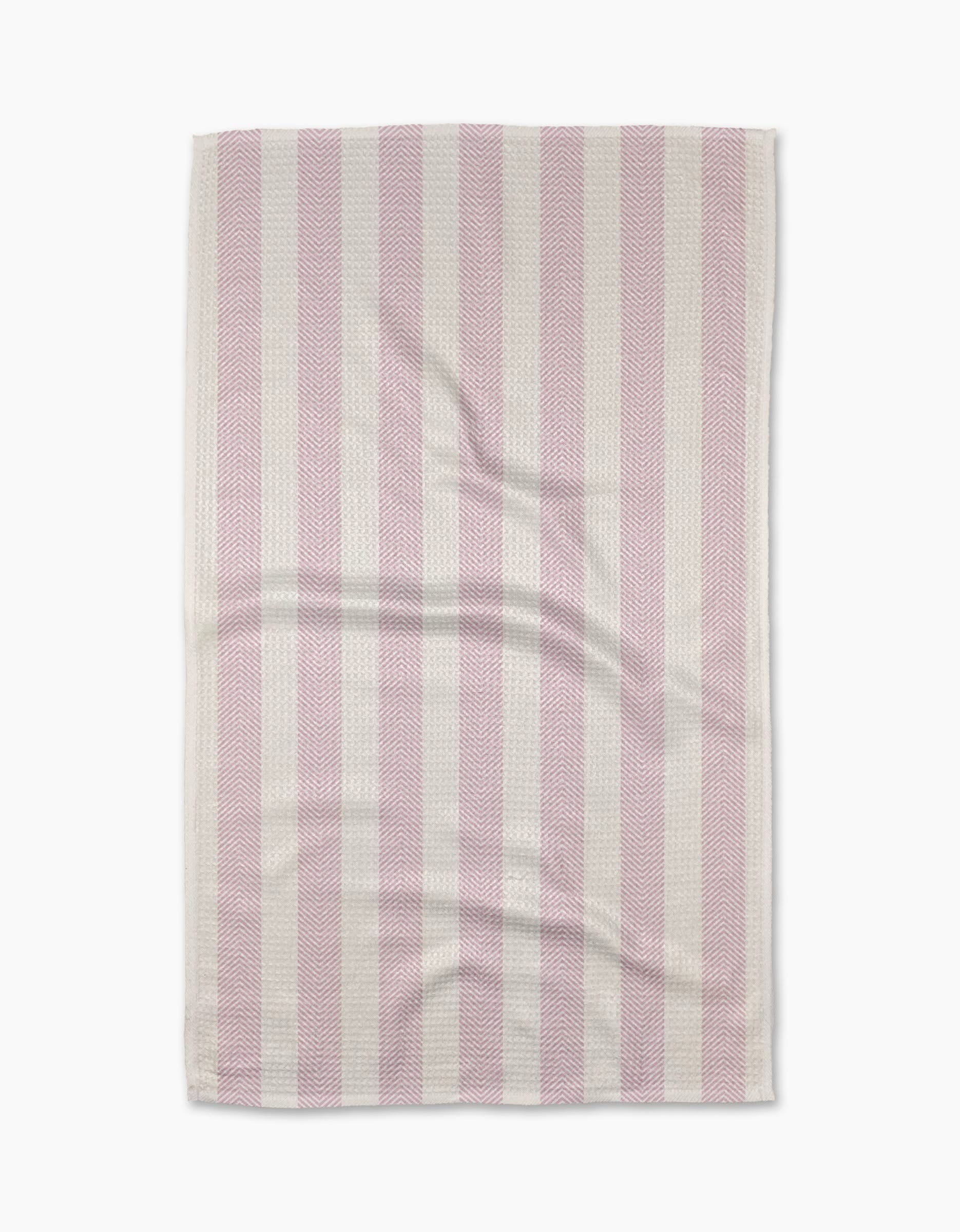 The Teri the Butter Pink Chevron Stripe tea towel features alternating vertical pink and white stripes, a slightly wrinkled texture, and neatly finished edges, displayed against a white background.