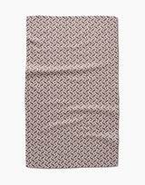 The Hufton Studio Plated Fall Berry Natural tea towel features a repeating geometric pattern in brown, tan, and white that creates a 3D cube effect. Made from Geoweave fabric, the towel is shown flat on a white background with visible creases.