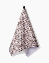 A Hufton Studio Plated Fall Berry Natural tea towel with a brown and white geometric design hangs from a black loop against a plain white background, crafted from durable Geoweave fabric.