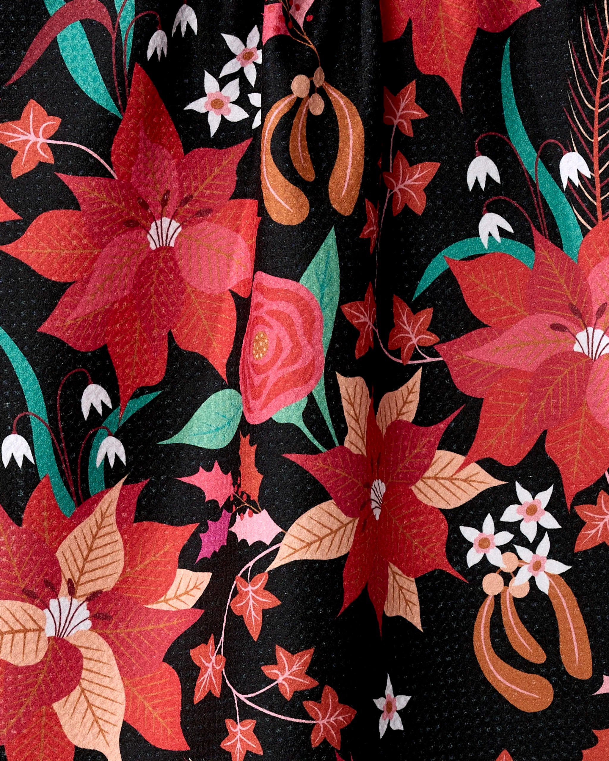The Rachel Parker "Poinsettia" kitchen towel features red, orange, and pink poinsettias, green and brown leaves, white blossoms, and berries on a black textured background. Made from recycled materials for a festive touch.