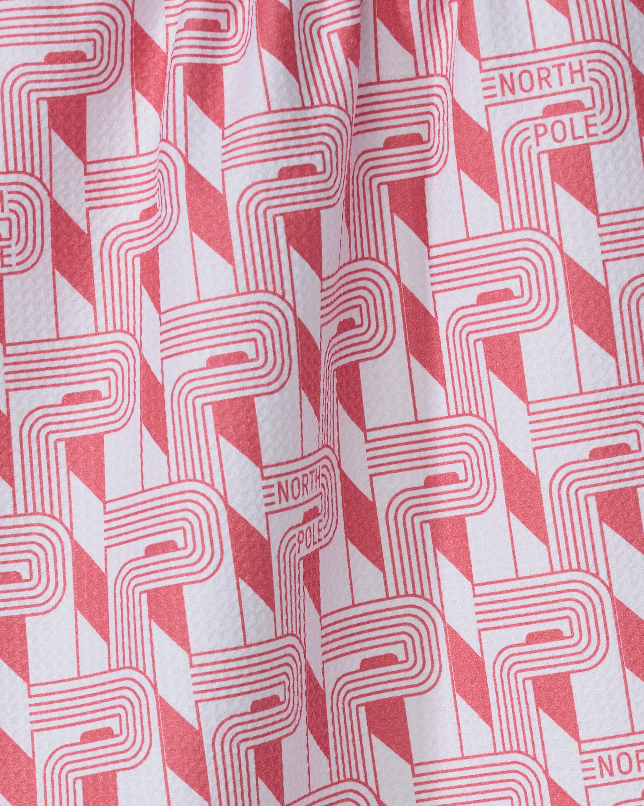 The Geometry Polemark kitchen towel features festive red and white geometric patterns with “NORTH POLE” accents, crafted from recycled materials for eco-friendly style.