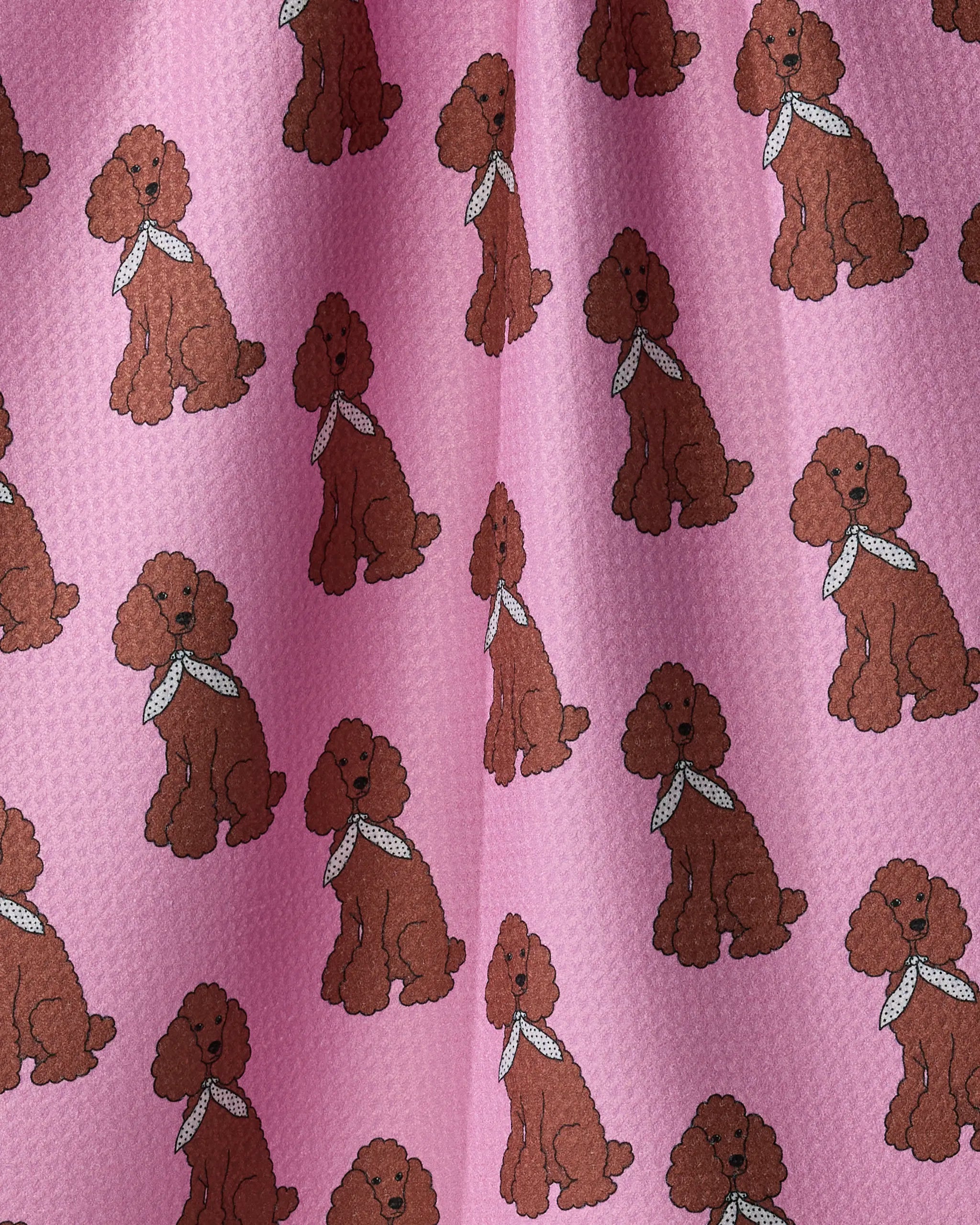 Add charm and personality to any kitchen with Geometry’s “Poodle Parade” recycled tea towel, featuring a playful pattern of cartoon brown poodles in white bandanas, repeated across a pink textured background.