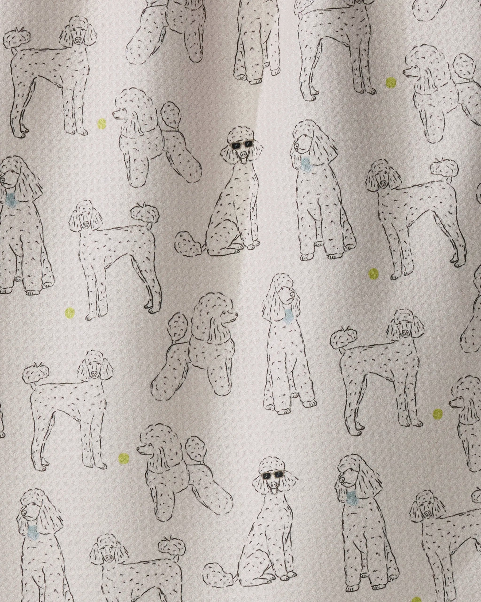 Introducing the “Poodle Party” tea towel by Geometry—a charming, eco-friendly kitchen accessory featuring outlined poodles in various poses, some adorned with blue bows, playfully scattered on a crisp white background with dainty yellow dots. Both stylish and functional, “Poodle Party” brightens up your kitchen while making drying dishes or tidying up a delightful experience.