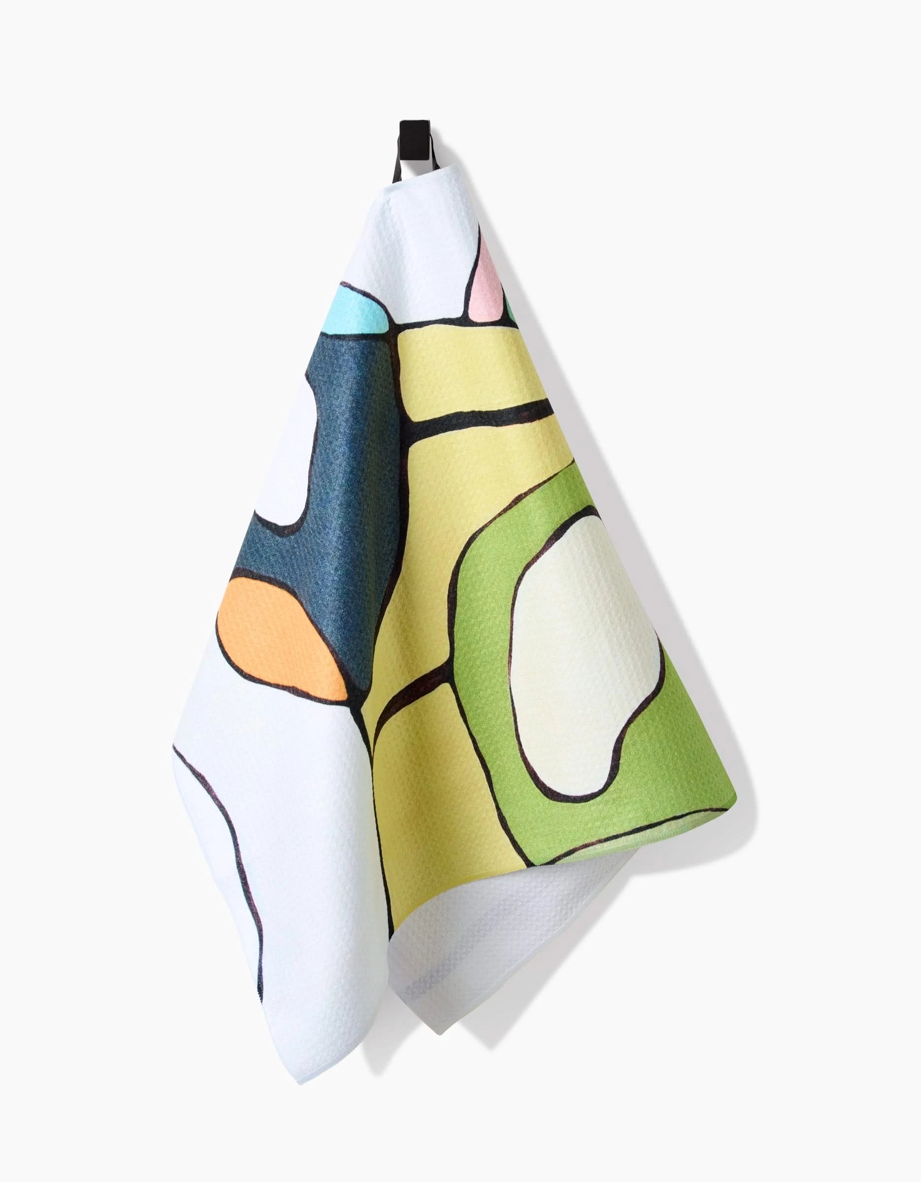 The Poppies on Yellow tea towel by Rachel Austin, made from recycled materials, hangs from a black hook against a white background, displaying colorful abstract shapes.