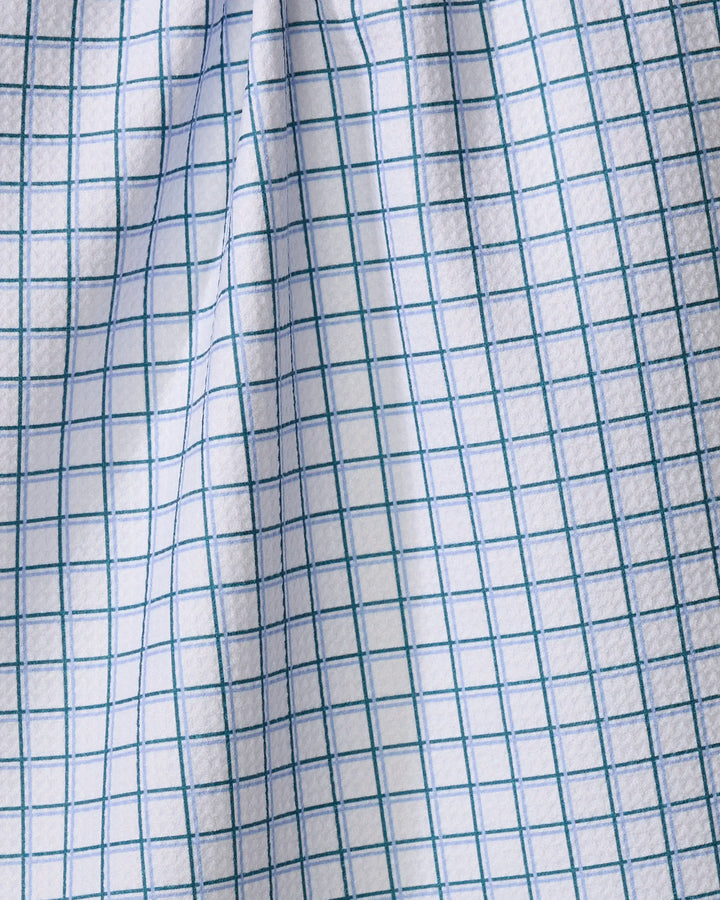 A close-up of The Buy Guide’s Preppy - Emerald French Blue tea towel, featuring white Geoweave fabric with a blue grid pattern and gentle, shadowed folds.