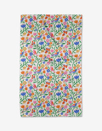 The Primrose Path tea towel by Charlie Rowan Designs features a colorful floral pattern—purple, orange, red, and pink flowers with green stems—on white Geoweave fabric for great absorbency and durability.