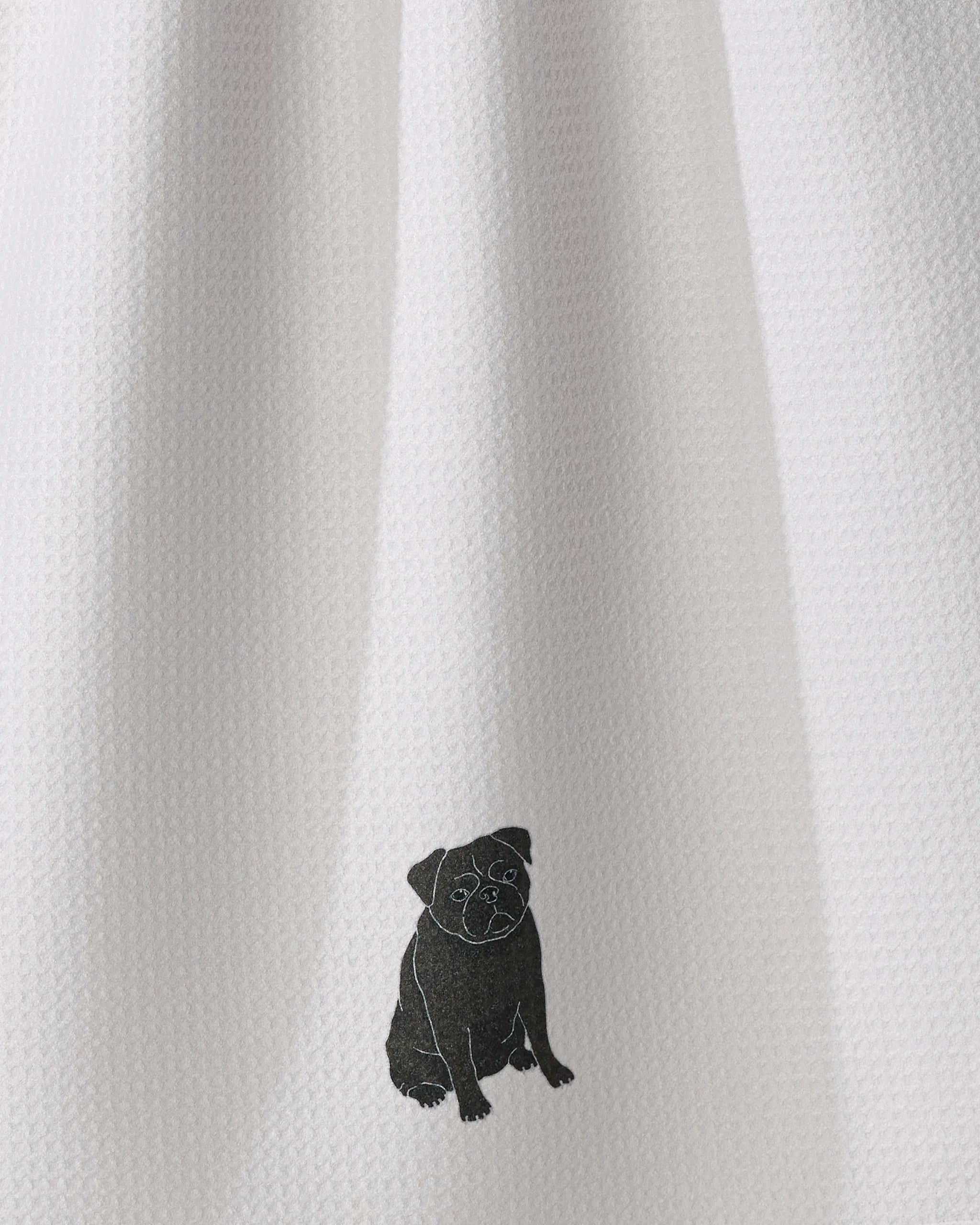 Geometry’s “Pug Pose” tea towel features a simple black outline drawing of a sitting pug on a textured white fabric background, blending charm with practicality. Made from recycled materials, it’s ultra-absorbent and ideal for everyday kitchen use.
