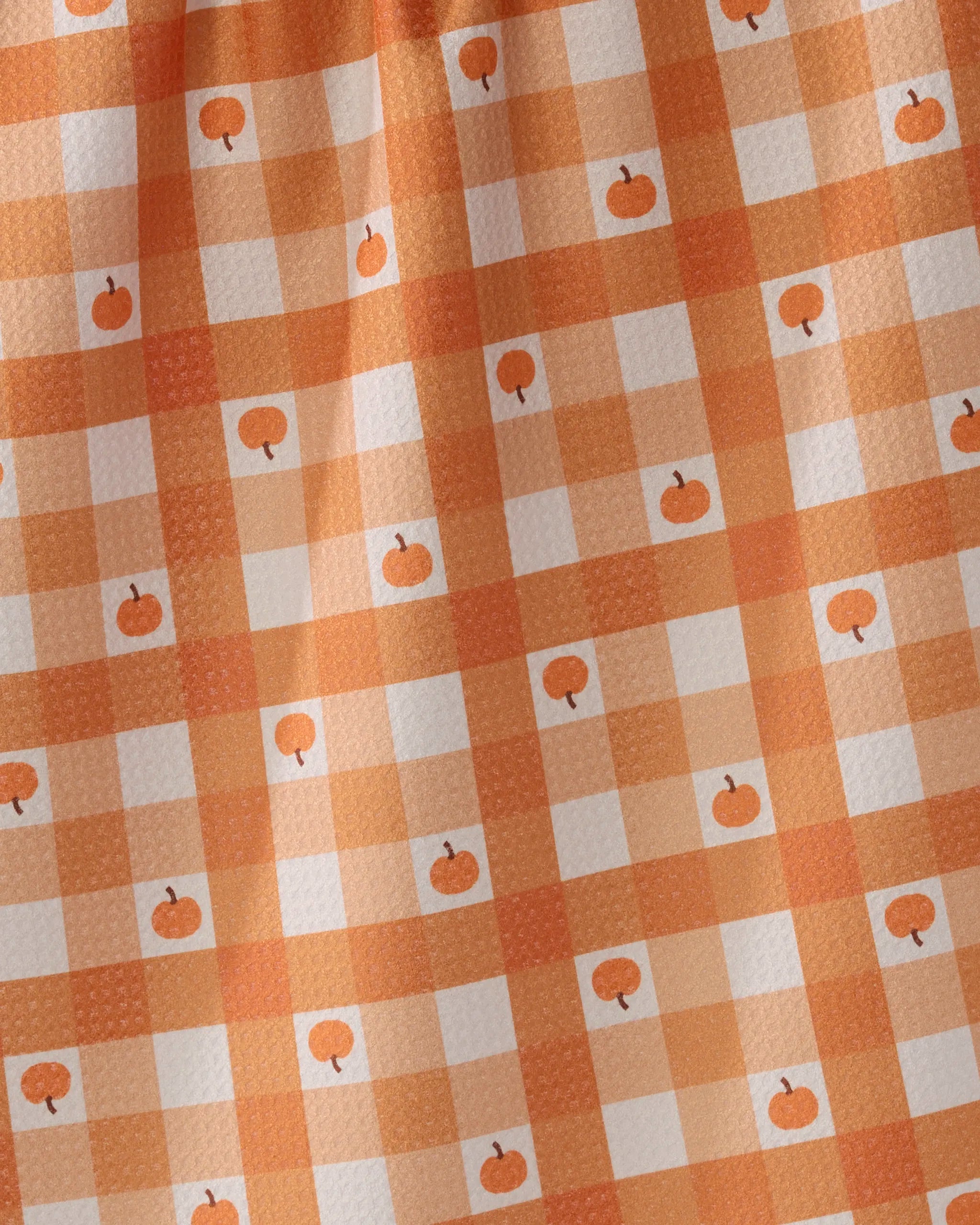 The Geometry Pumpkin Check tea towel features an orange and white checkered pattern with small pumpkins, creating a festive autumn look. Made from ultra-absorbent, recycled materials, it’s perfect for seasonal kitchen decor.