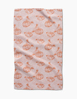 Pumpkin Field by Charlie Rowan Designs is a tea towel with hand-drawn orange pumpkins, leaves, and abstract speckles on a light background—perfect for adding charm to your kitchen.