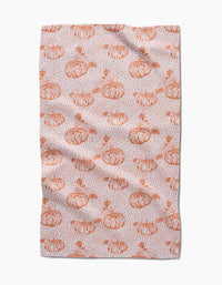 Pumpkin Field by Charlie Rowan Designs is a tea towel with hand-drawn orange pumpkins, leaves, and abstract speckles on a light background—perfect for adding charm to your kitchen.