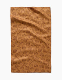 Aubrey Fairchilds Pumpkin Patchwork tea towel features a brown background with an all-over pattern of darker brown, outlined pumpkins, shown flat with subtle wrinkles.