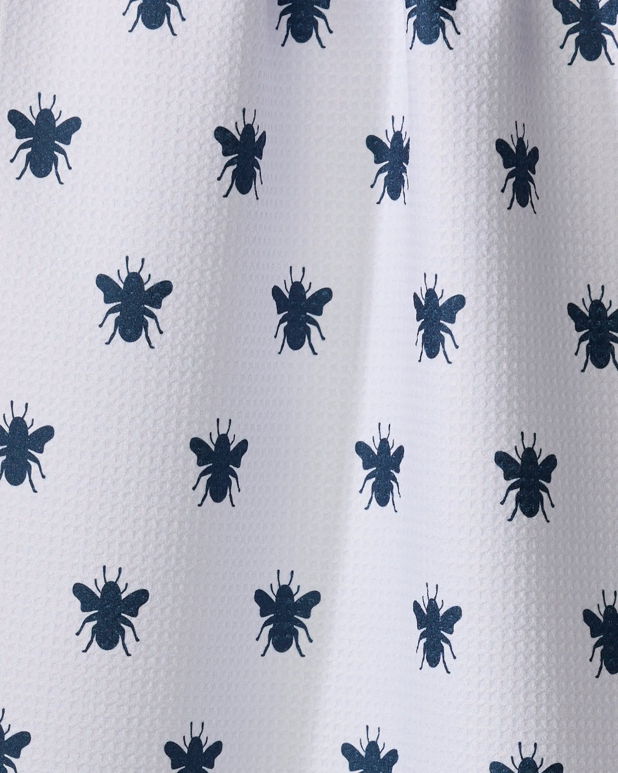 The Buy Guide's Queen Bee - Navy tea towel features ultra-absorbent white fabric with a textured waffle weave and a repeating pattern of dark blue bee silhouettes, blending stylish design with practical kitchen use.