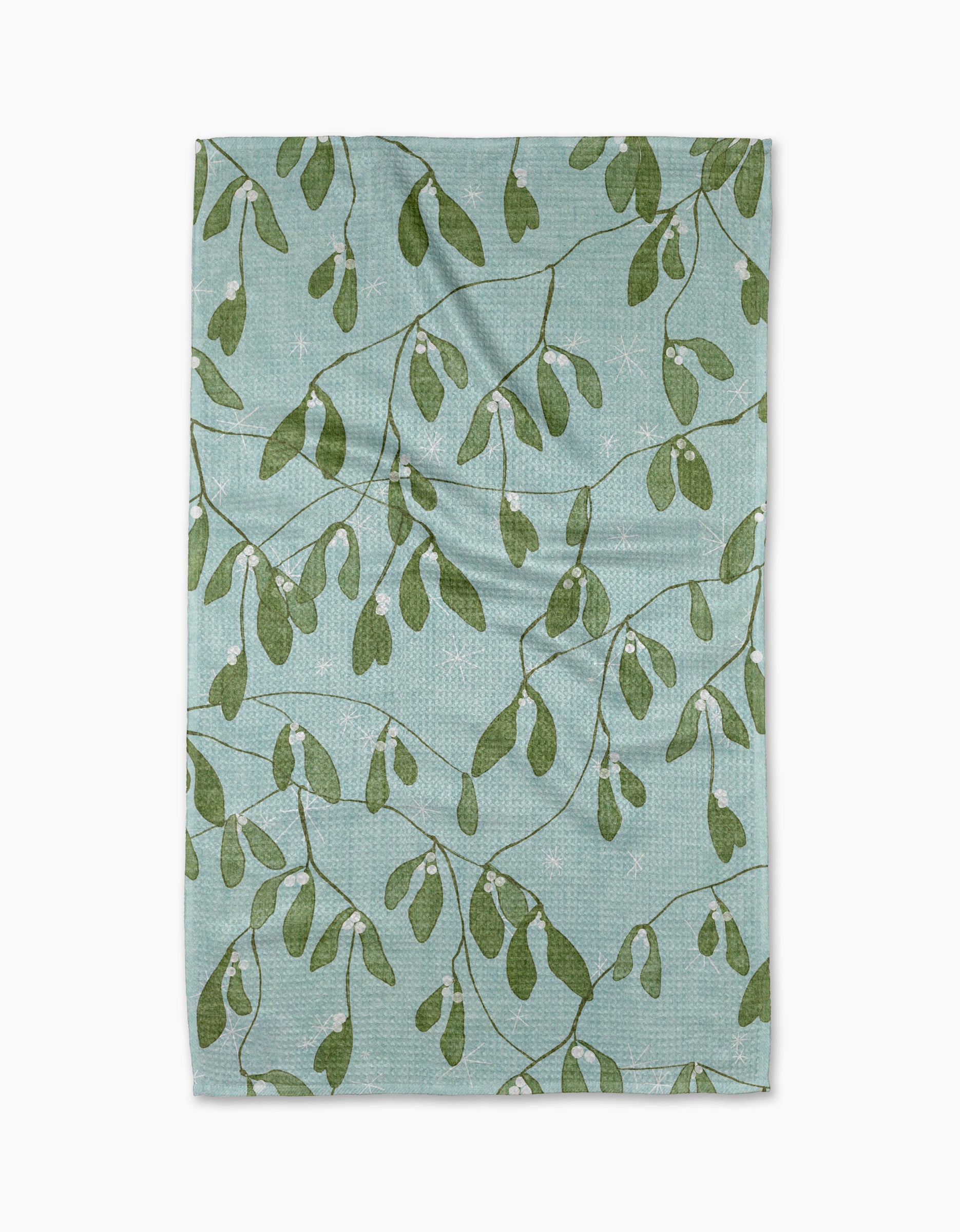 The Quiet Morning dish towel by Pascale Dilger is light blue and absorbent, featuring green leafy branches and small white dots throughout the fabric.