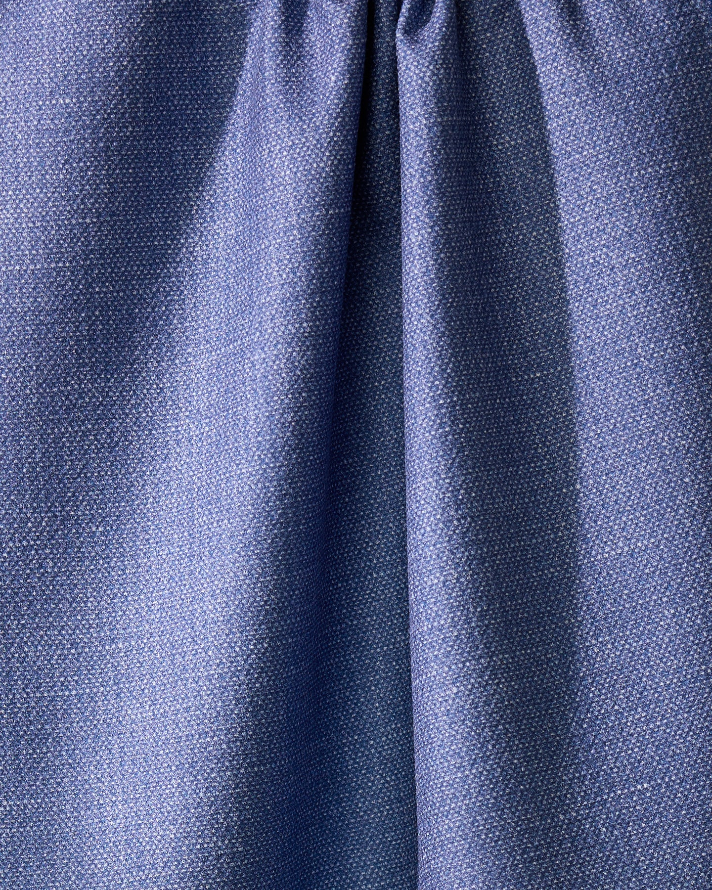 Close-up of Geometrys Rainfield, a blue absorbent kitchen towel crafted from recycled materials, with a subtle textured pattern and gathered seam near the top for soft folds and shadows.