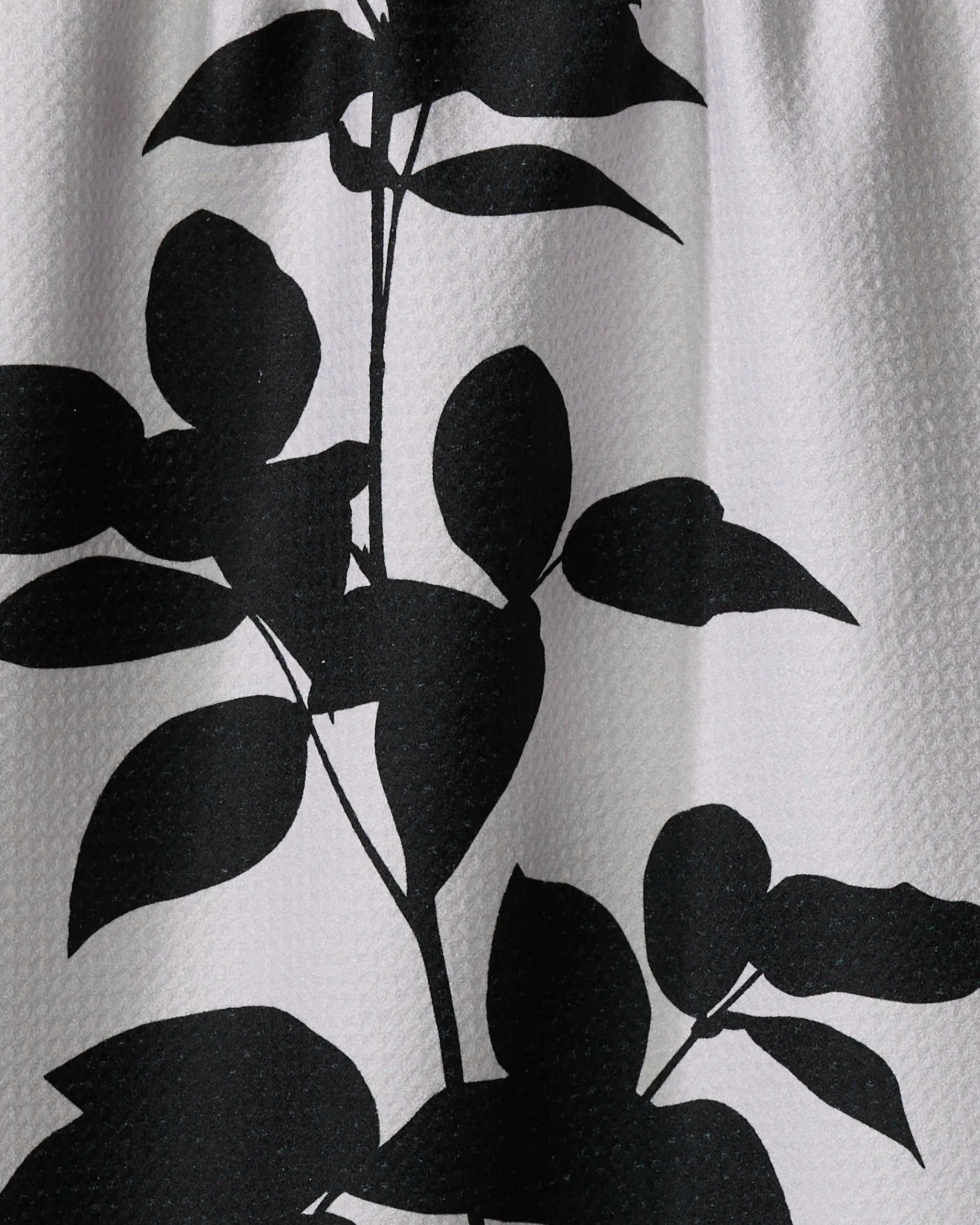 The Raspberry by PrintedPlant features a black silhouette of leafy stems with rounded leaves on textured white, ideal for a stylish recycled kitchen towel.