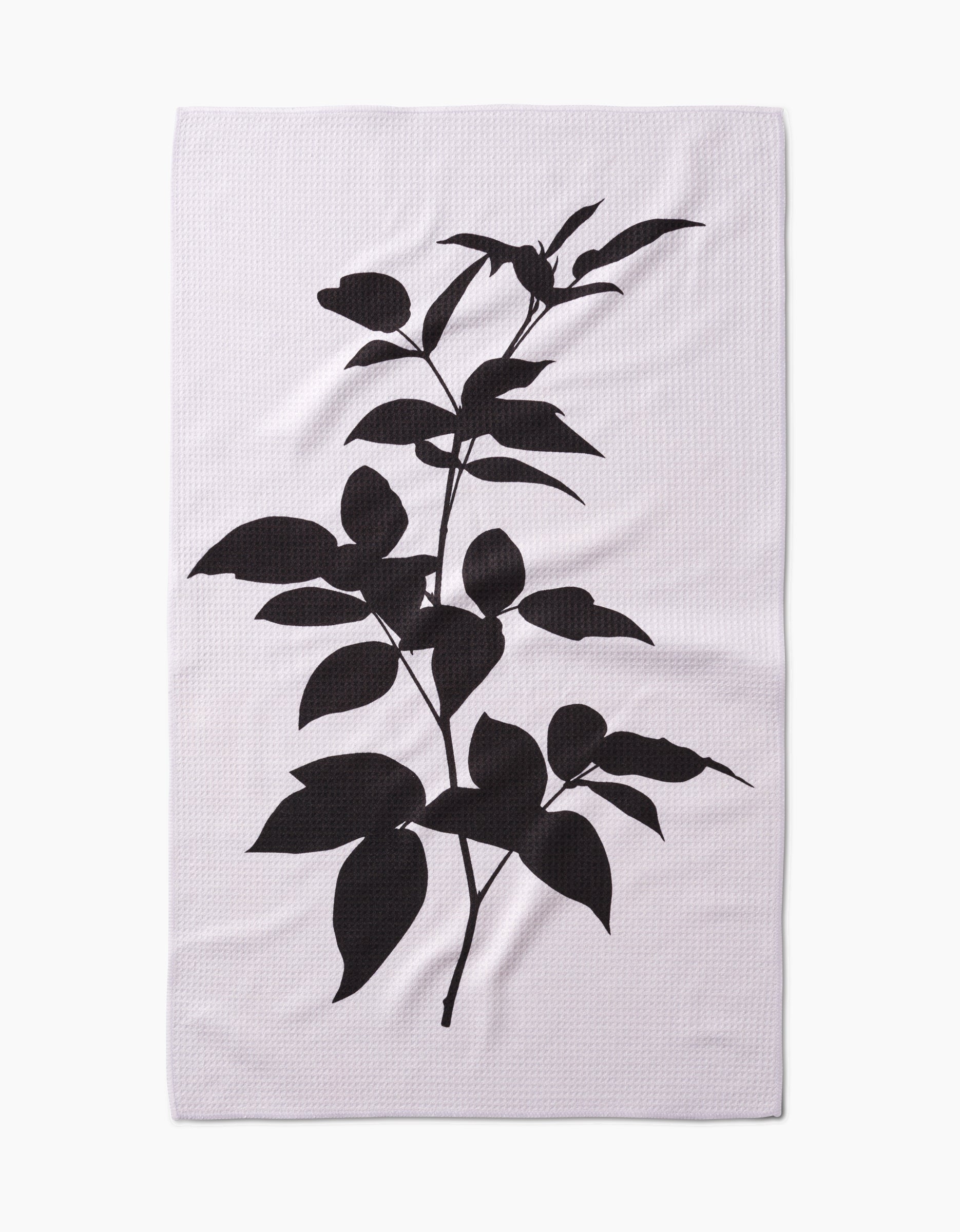 A white rectangular PrintedPlant Raspberry Tea Towel features a bold black silhouette of a leafy plant with branches, leaves, and buds, centered on light Geoweave™ fabric made from post-consumer recycled materials.
