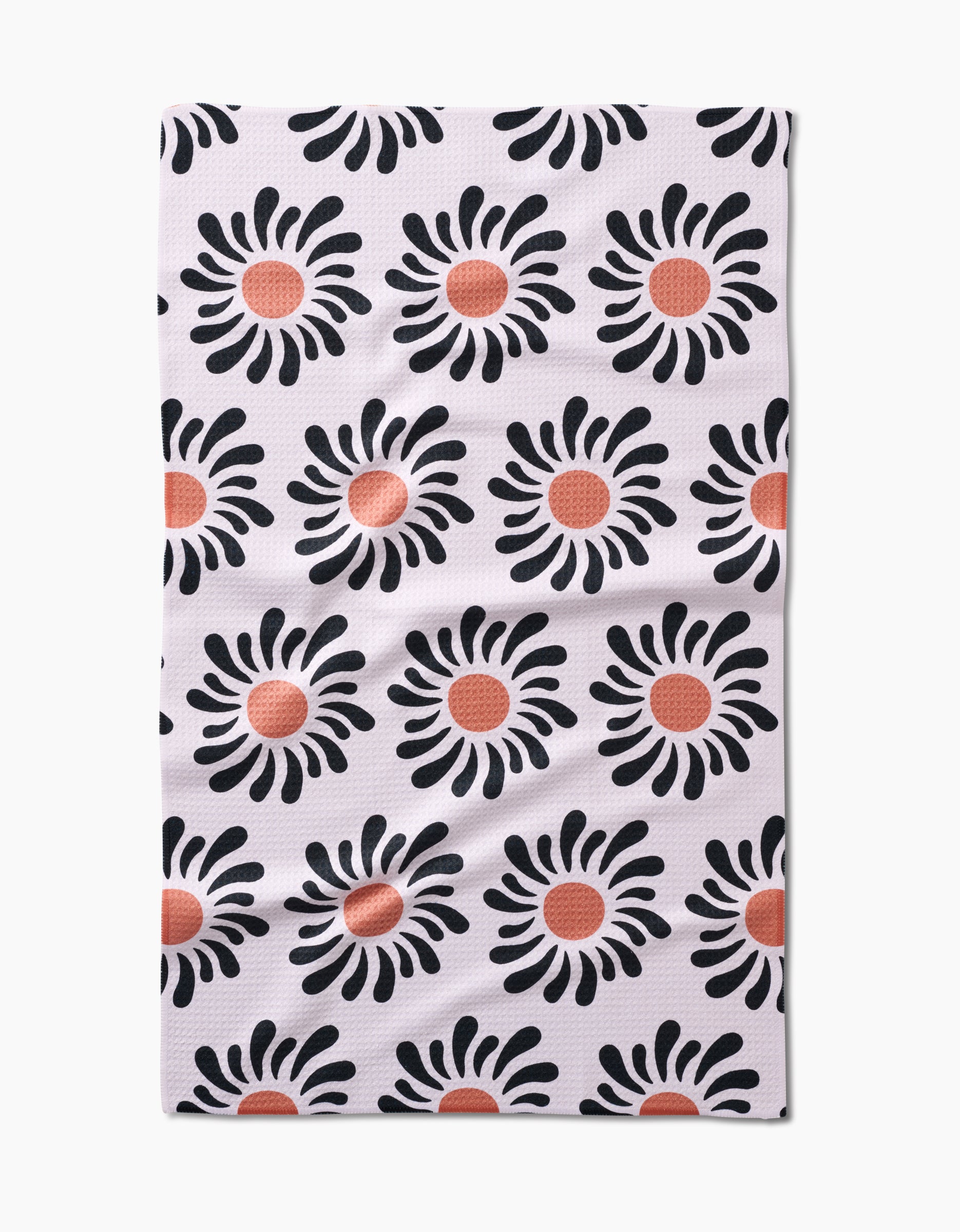 The Realm Refillery tea towel features a white background with rows of black flowers accented by red-orange centers. Made from eco-friendly Geoweave fabric, this stylish and sustainable design comes from Realm Refillery.