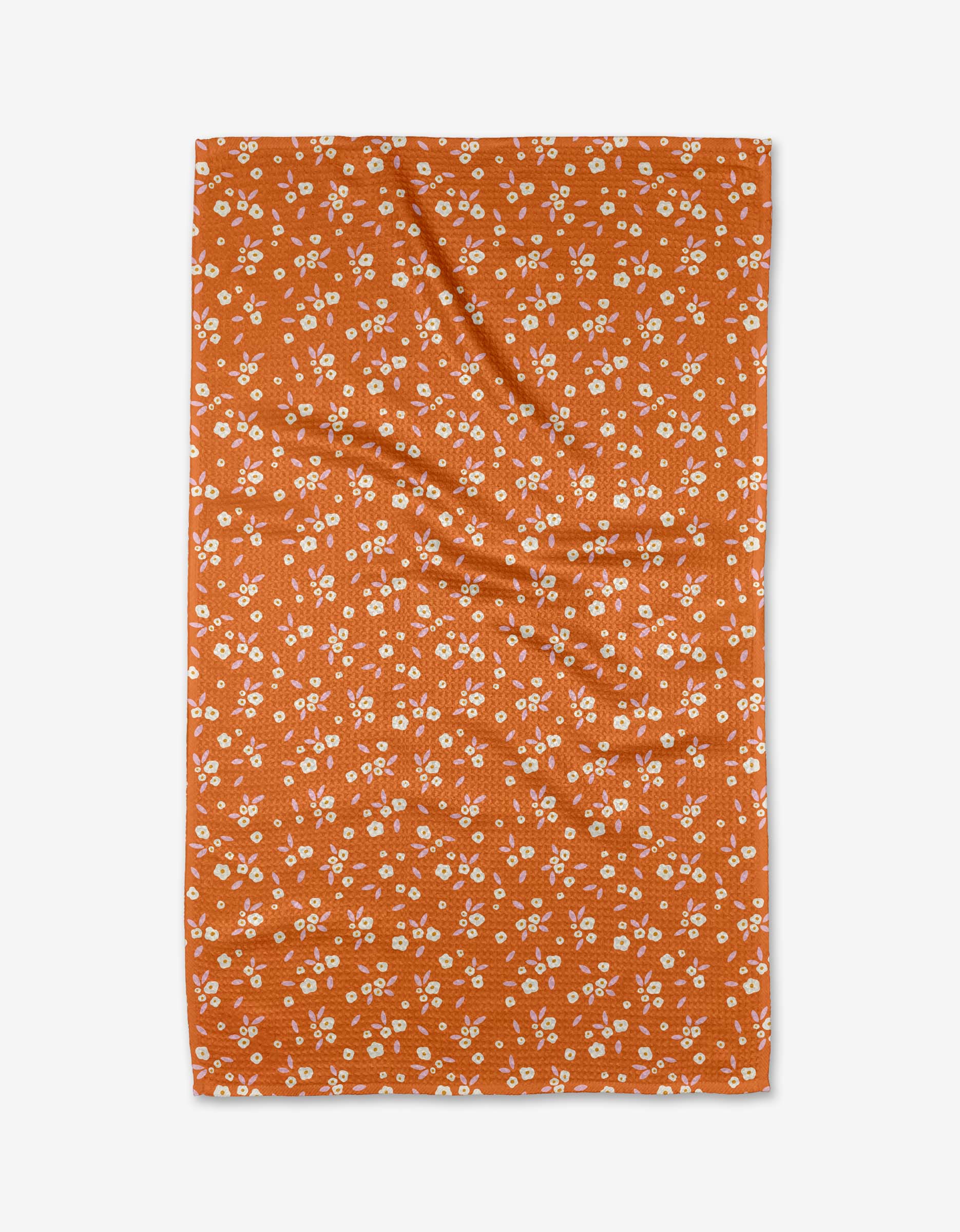 A Red Field of Flowers tea towel by Megan Roy, featuring a white floral pattern on soft Geoweave fabric, is shown laid flat on a white background.