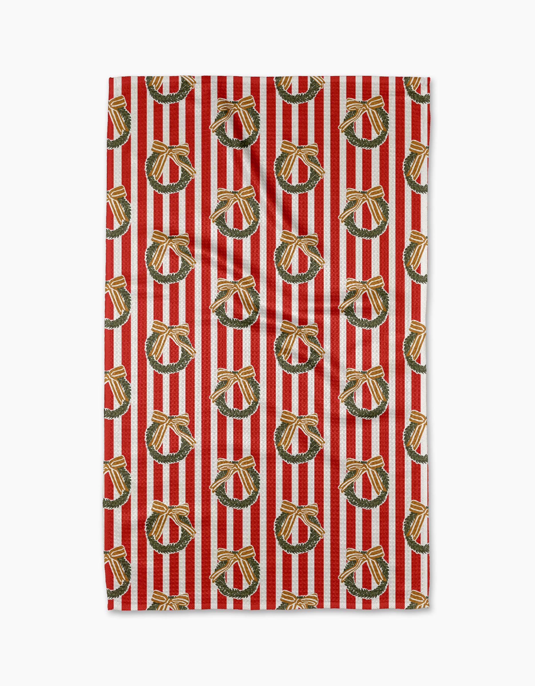 The "Red Wreaths" tea towel by Charlie Rowan Designs features red and white stripes with green holiday wreaths and gold bows, crafted from recycled materials for ultra absorbency.