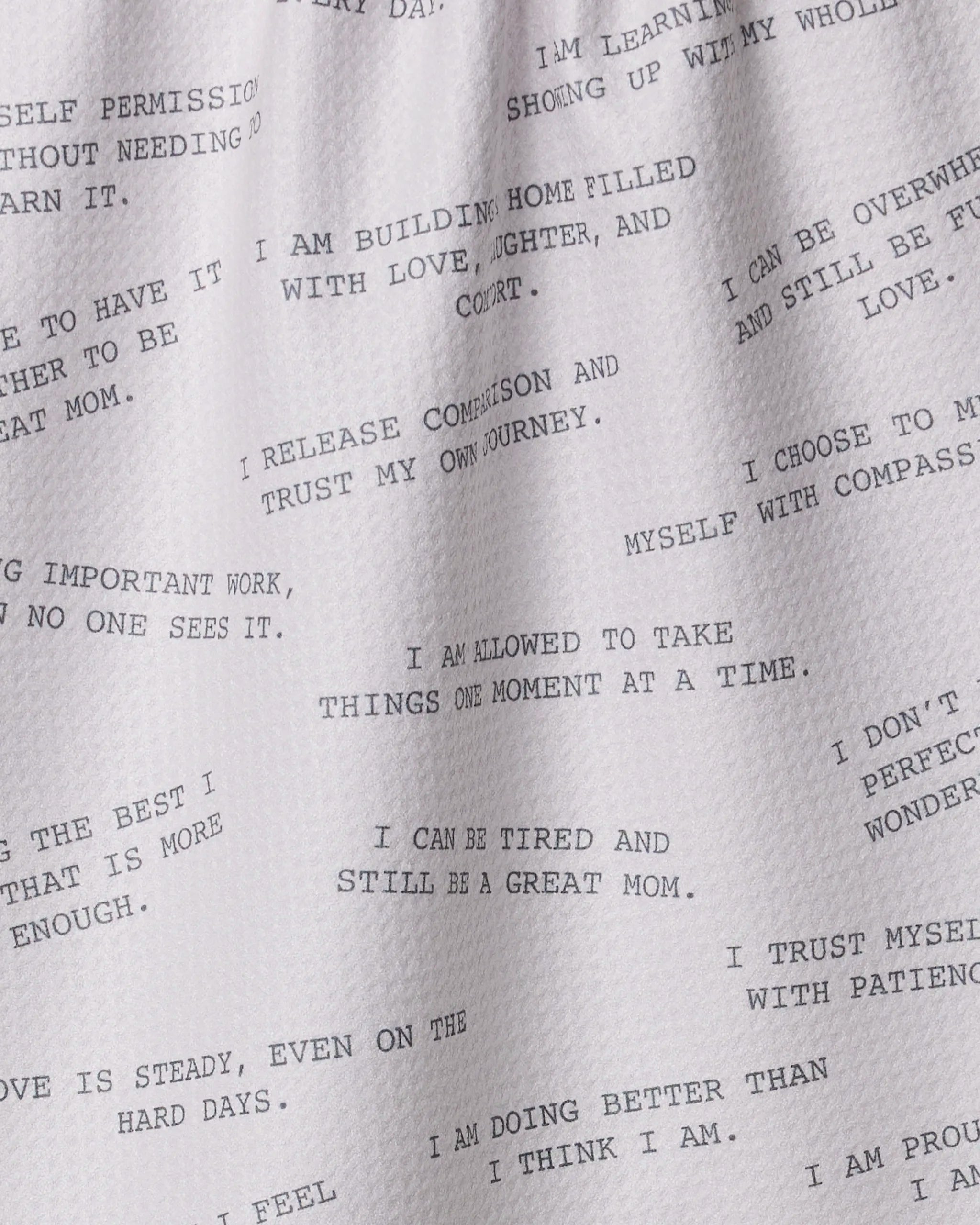 Geometry’s Reminders for Mom tea towel features black text with positive affirmations like “I am allowed to take things one moment at a time”—an eco-friendly kitchen towel that brings comfort and positivity to your home.