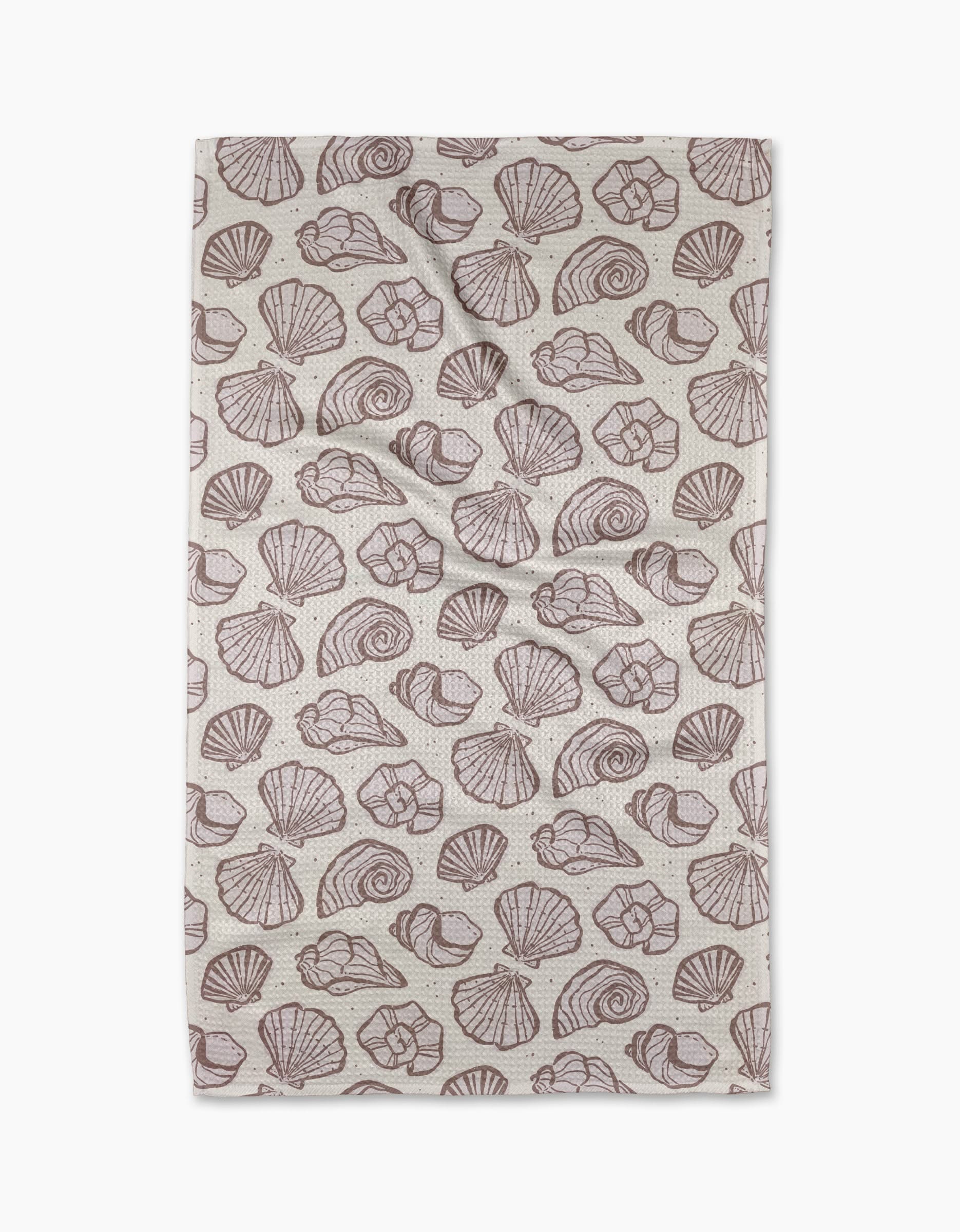 The Retro Coastal Seashells in Neutral tea towel by Teri the Butter features a repeating brown seashell pattern on beige, including scallops and spirals. Made from recycled materials, its shown flat with slight creases.