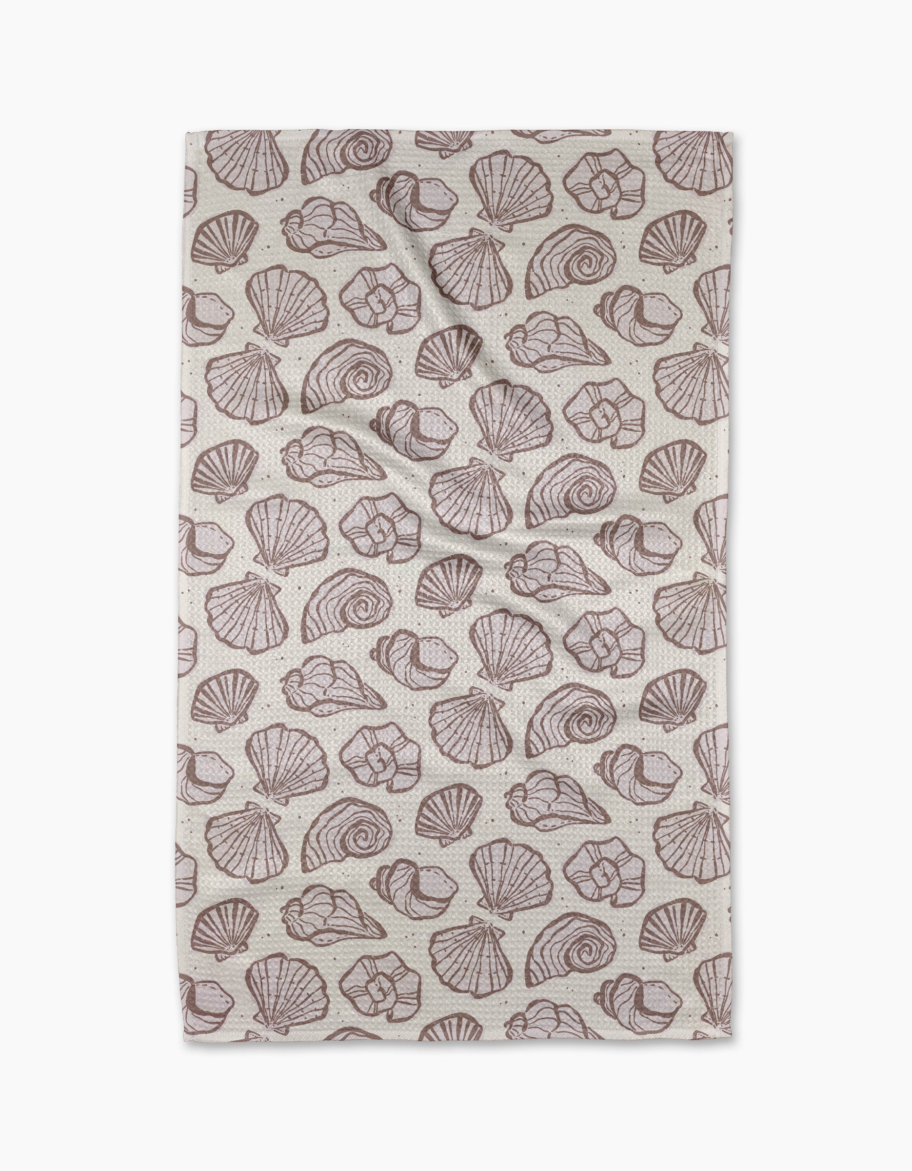 The Retro Coastal Seashells in Neutral tea towel by Teri the Butter features a repeating brown seashell pattern on beige, including scallops and spirals. Made from recycled materials, its shown flat with slight creases.