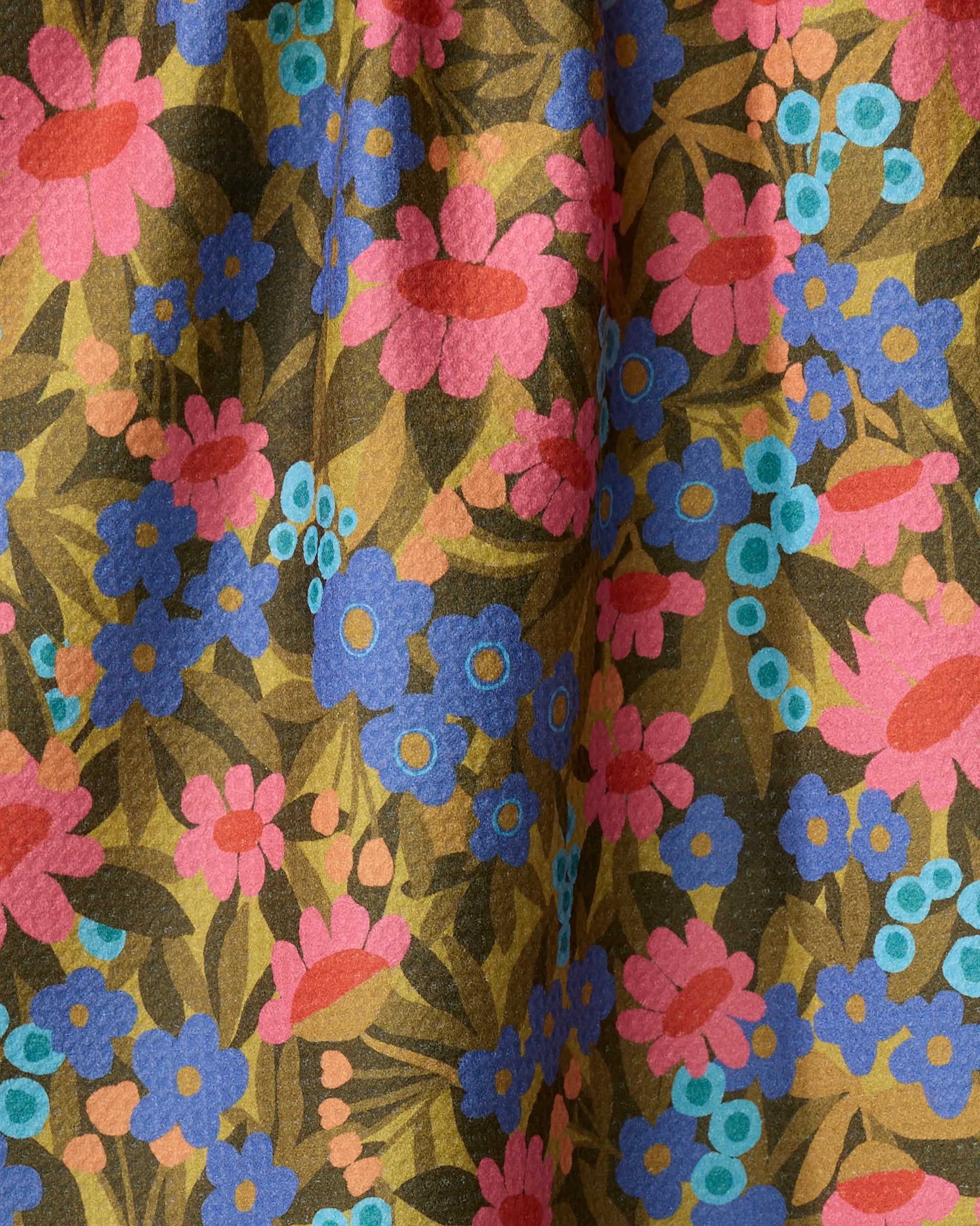 Close-up of Lisa Nelson's Retro Garden kitchen towel, made from recycled materials with a colorful floral print—pink, blue, and teal flowers plus green and brown leaves on a yellow background. The fabric is gently folded with a subtle texture.
