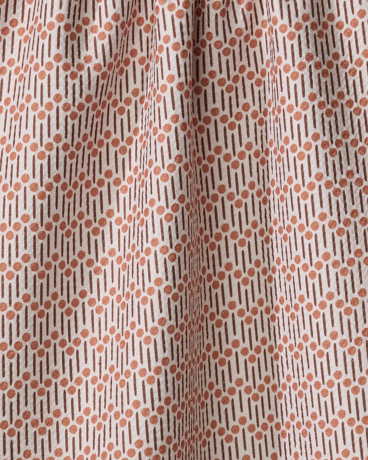 A close-up of Teri the Butter's Retro Geo tea towel, made from quick-drying fabric, showcases a cream background with rust-colored dots and vertical lines in a subtle geometric repeat pattern.