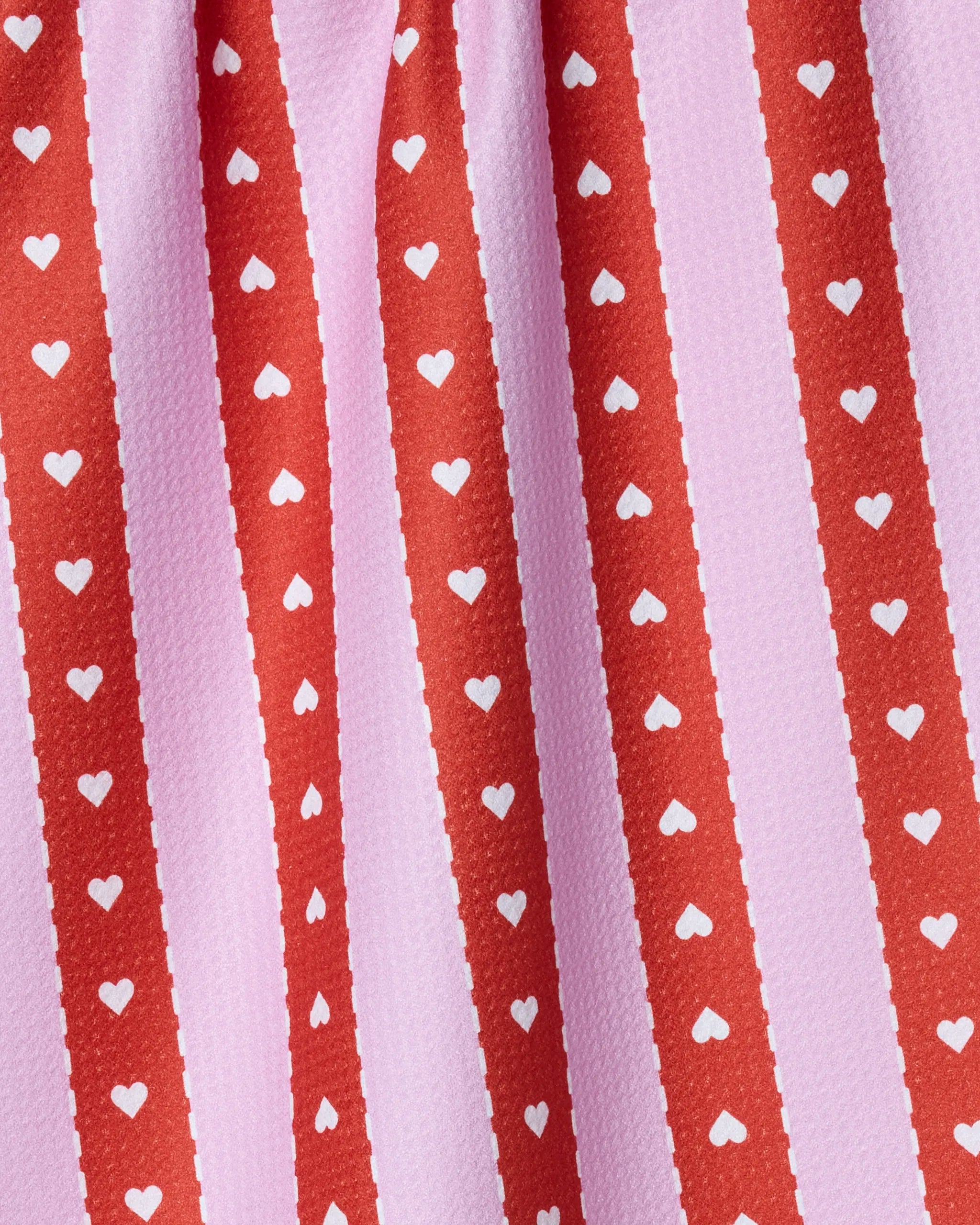 The Geometry Ribbon Hearts kitchen towel features red vertical stripes with small white hearts alternating with light pink stripes on a textured, absorbent fabric for a playful and romantic look.