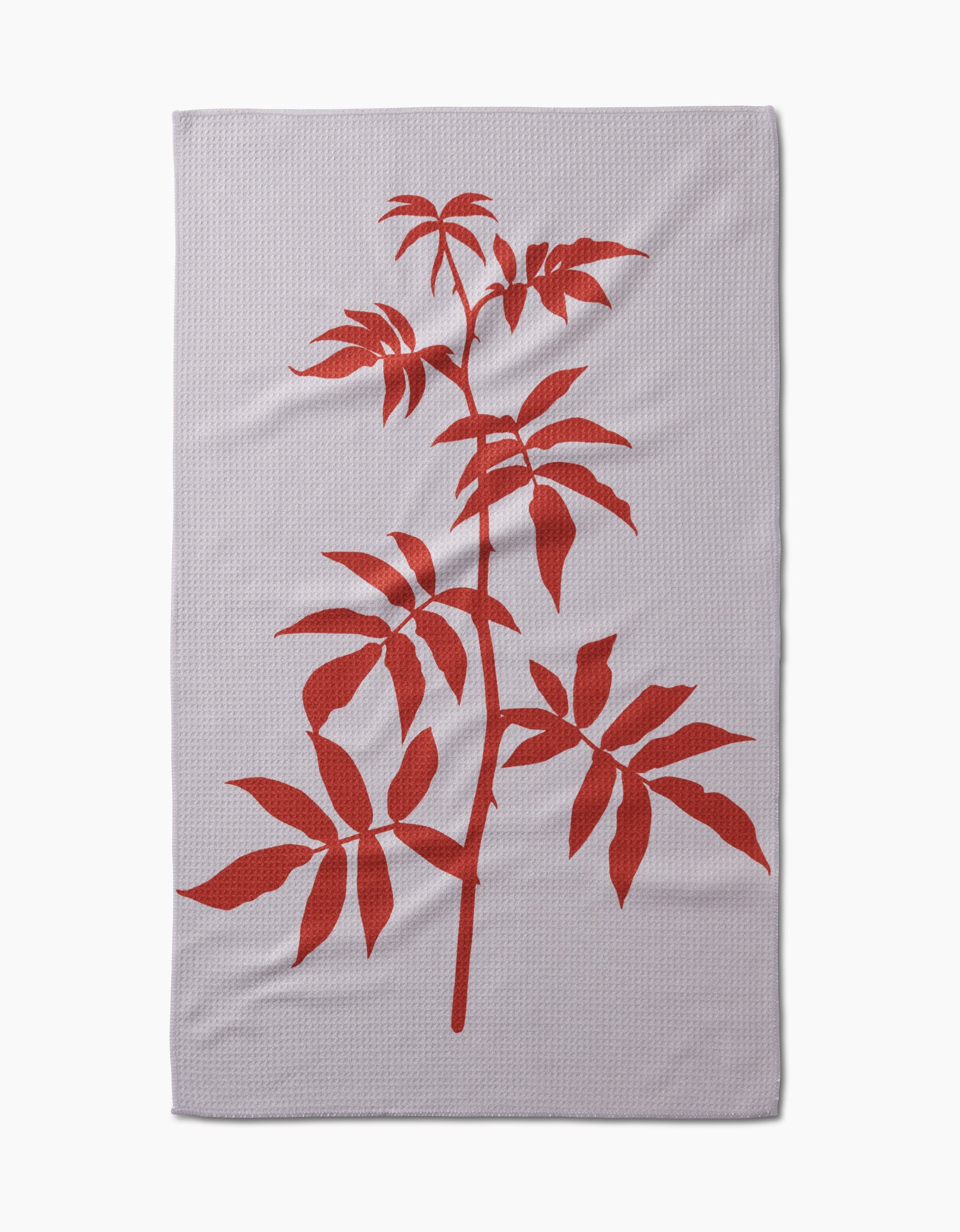 The Rose tea towel by PrintedPlant is a light grey rectangular Geoweave fabric towel, featuring a large bold red illustration of a leafy plant branch diagonally across the surface.