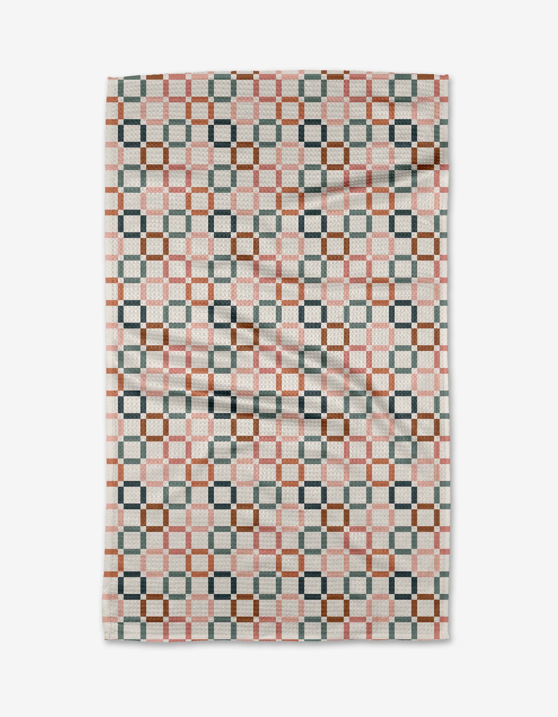 The Russet Crossroads blanket by Charlie Rowan Designs features a geometric checkerboard pattern in pink, brown, gray, and white Geoweave fabric, with interlocking shapes for a modern look—reminiscent of the cozy Geometry House Tea Towel. Slightly wrinkled.