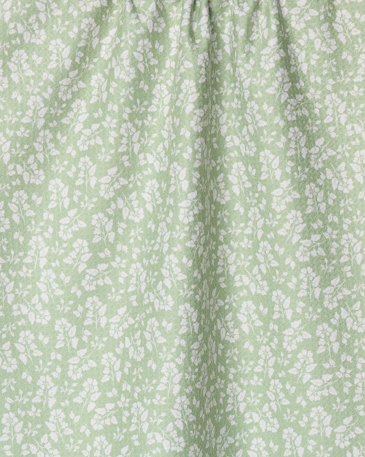 The Sage Garden towel by Danelys Sidron features a light green, ultra-absorbent fabric with delicate white floral patterns and gentle top gathering for soft folds—an ideal, textured accent to brighten your kitchen.