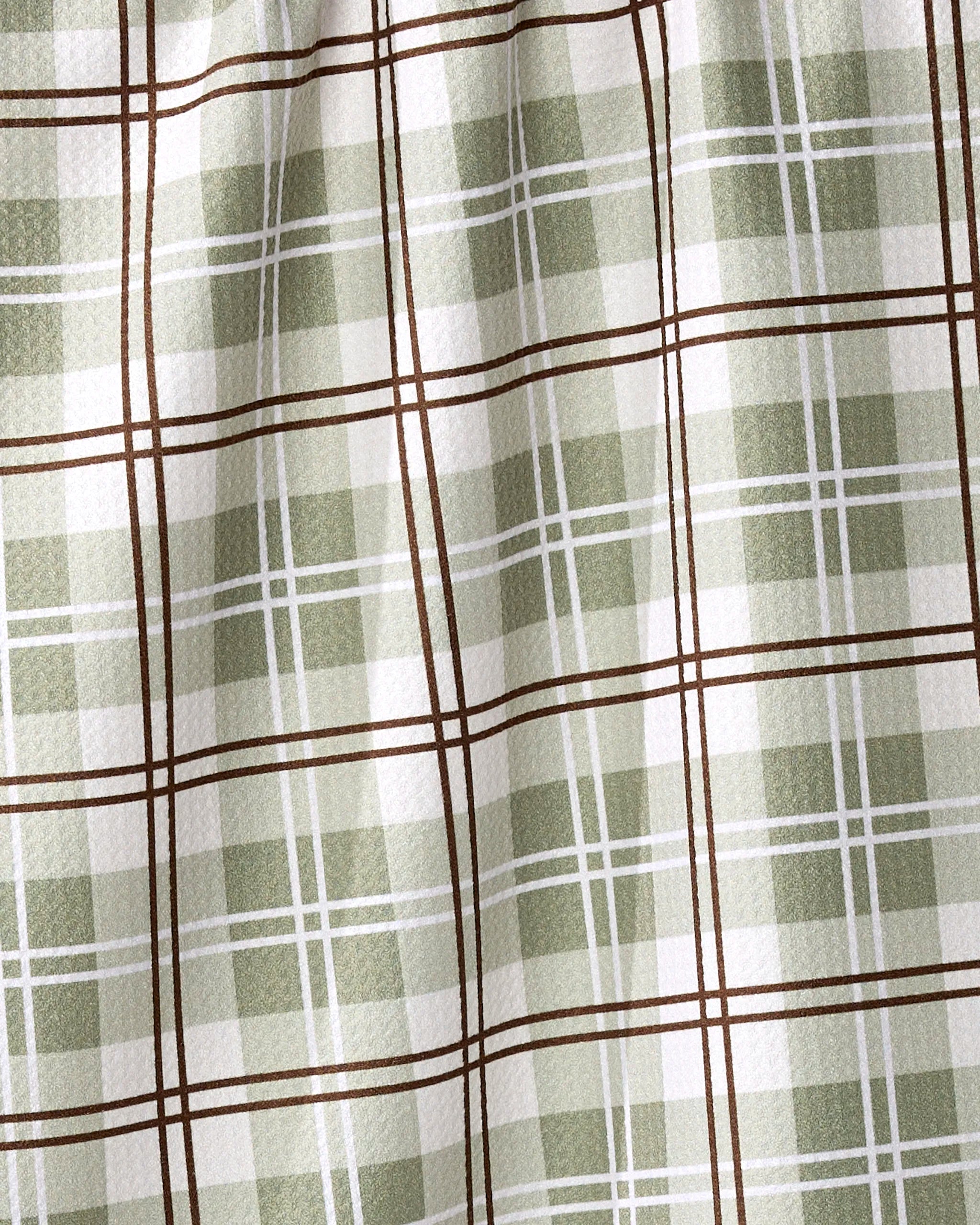 A close-up of the Sage Season tea towel by Ashley Reeves shows its green and white plaid with brown lines forming squares. Made from recycled materials, this textured fabric is quick-drying and ideal for everyday use.