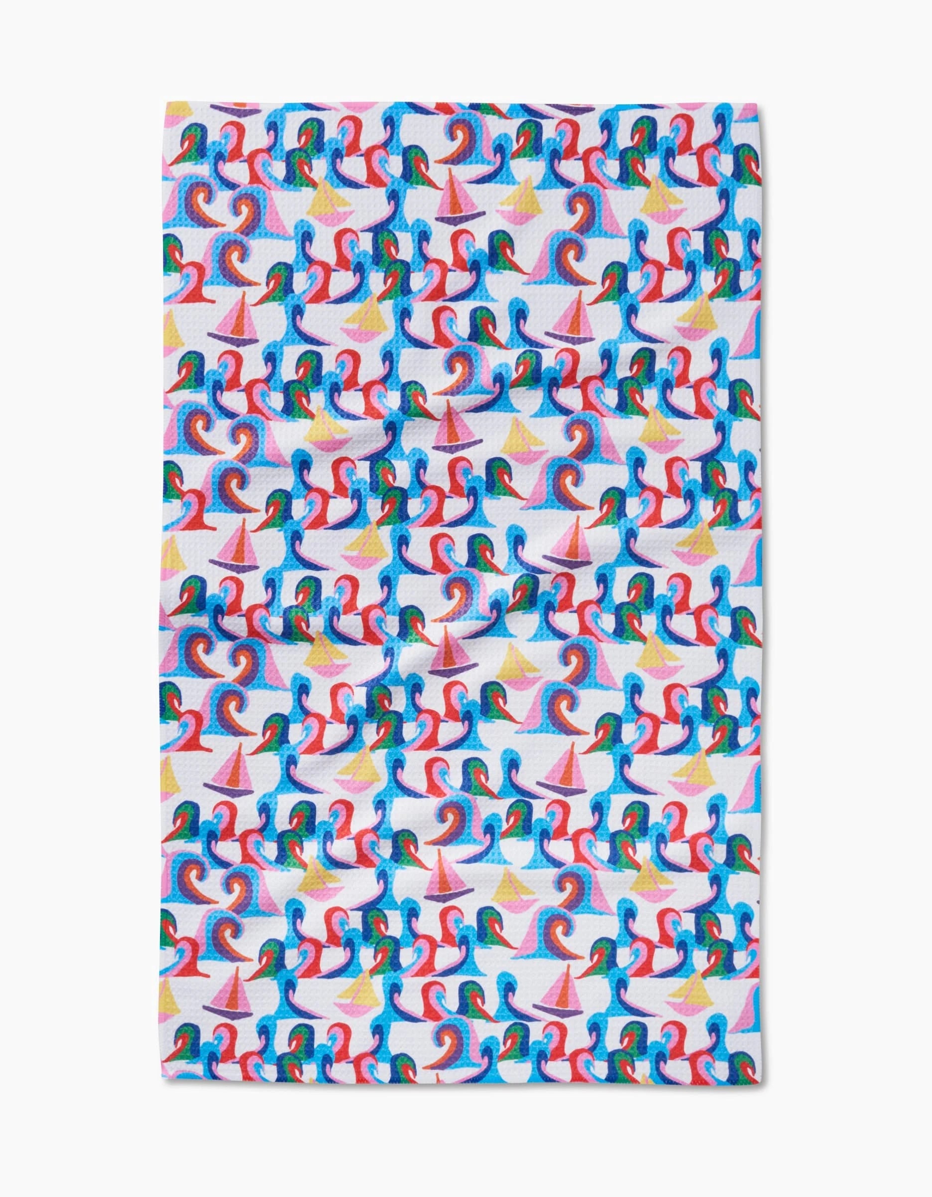 The Sail Safe rectangular cloth by Ania Zwara Art is made from ultra-absorbent Geoweave fabric and features blue and red waves, yellow stars, and pink sailboats on a white background.
