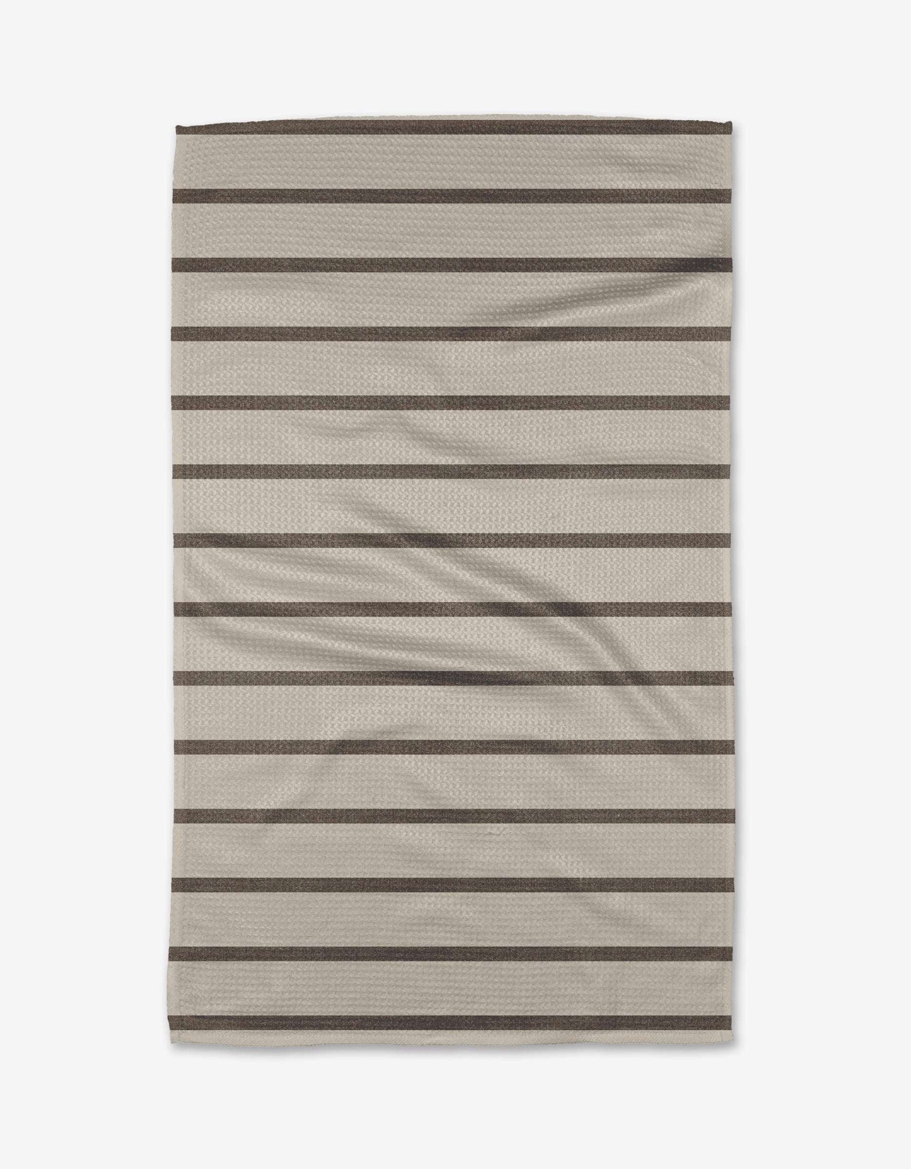The Salt Air Stripe dish towel by Jenny Keller features a beige rectangular design with horizontal dark brown stripes. Soft and slightly wrinkled, it’s perfect for everyday kitchen use.
