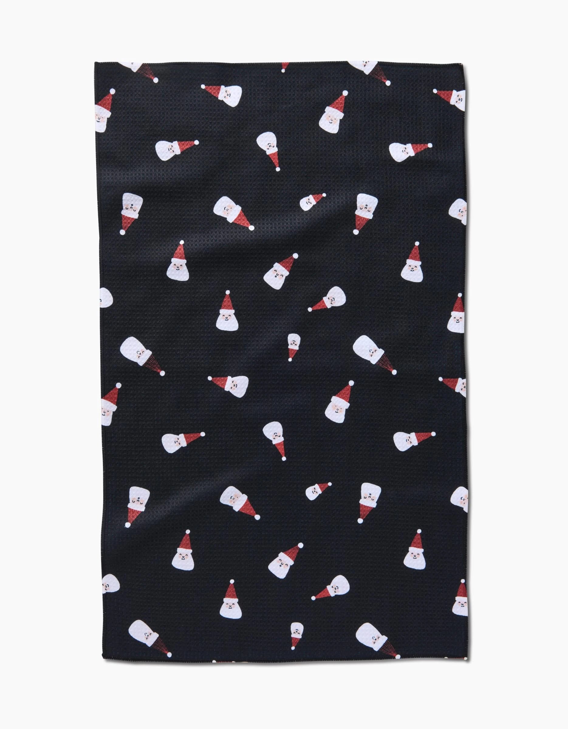 The Santa Faces tea towel by Coit Creative features a black ultra-absorbent fabric adorned with cartoon Santa faces in red hats—ideal for bringing festive cheer to your kitchen.