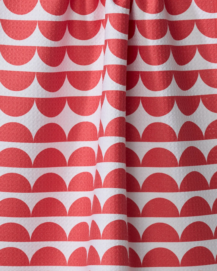 Close-up of The Buy Guide's Scallops - Red tea towel, made from recycled materials and featuring a repeating red semicircle pattern on white fabric with gentle folds for added texture.