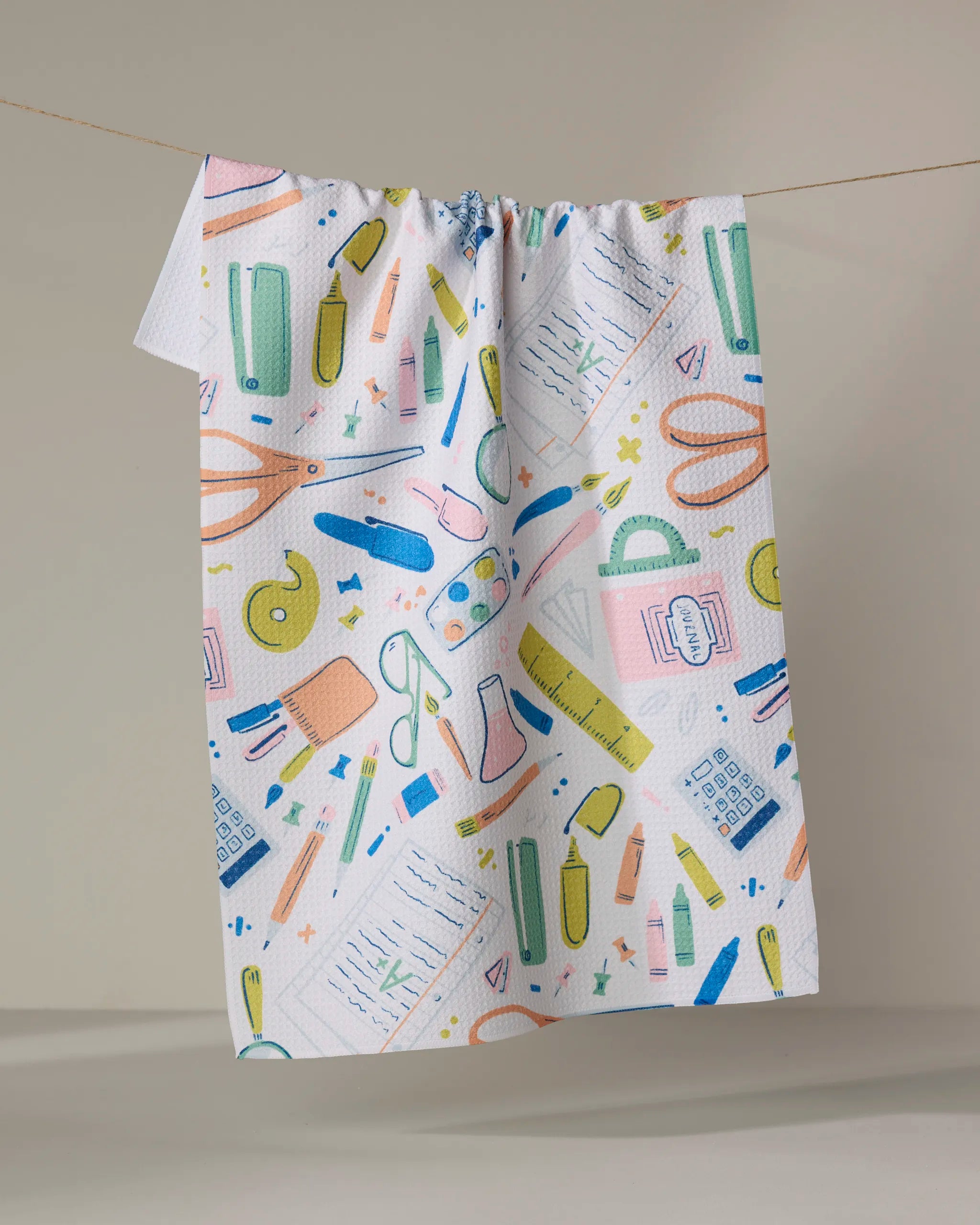 The School Days Light tea towel by Amy MacCready features colorful school supplies on white fabric. Quick-drying and charming, it’s perfect for brightening up any kitchen or classroom.