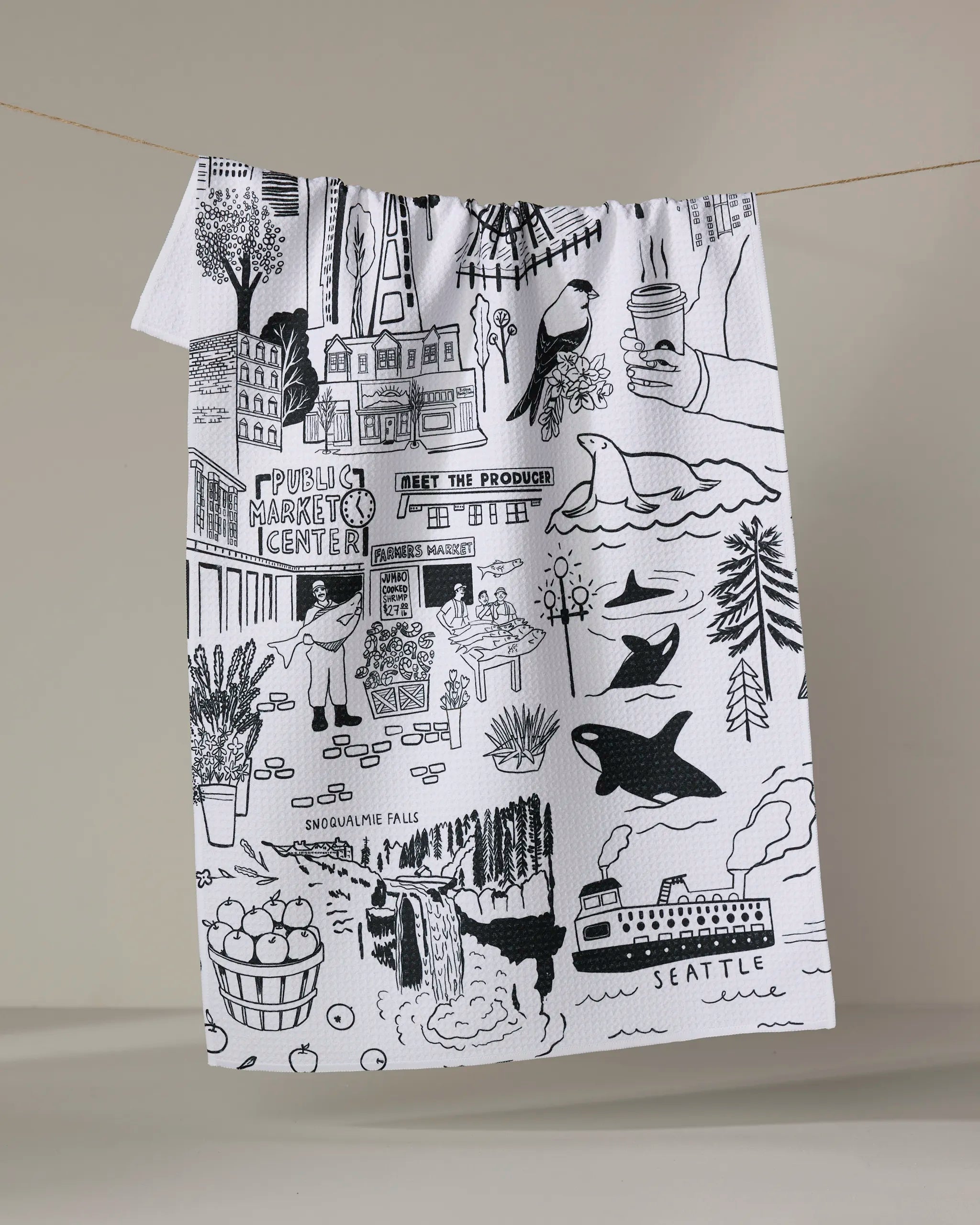 Elisabeth Wing's “Seattle” tea towel, crafted from recycled materials, features black illustrations of local landmarks, produce, animals, trees, and the Pike Place Market sign on white fabric—perfect for your kitchen.
