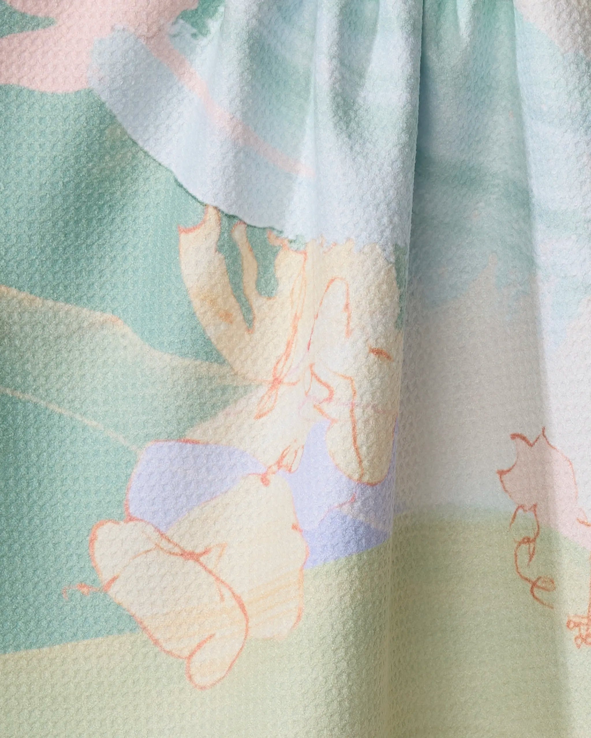 Close-up of the Kristina Baker Secret Fort recycled kitchen towel, featuring textured fabric with an abstract pastel print in green, blue, cream, and peach tones, accented by faint sketch-like line drawings and soft blended shapes.