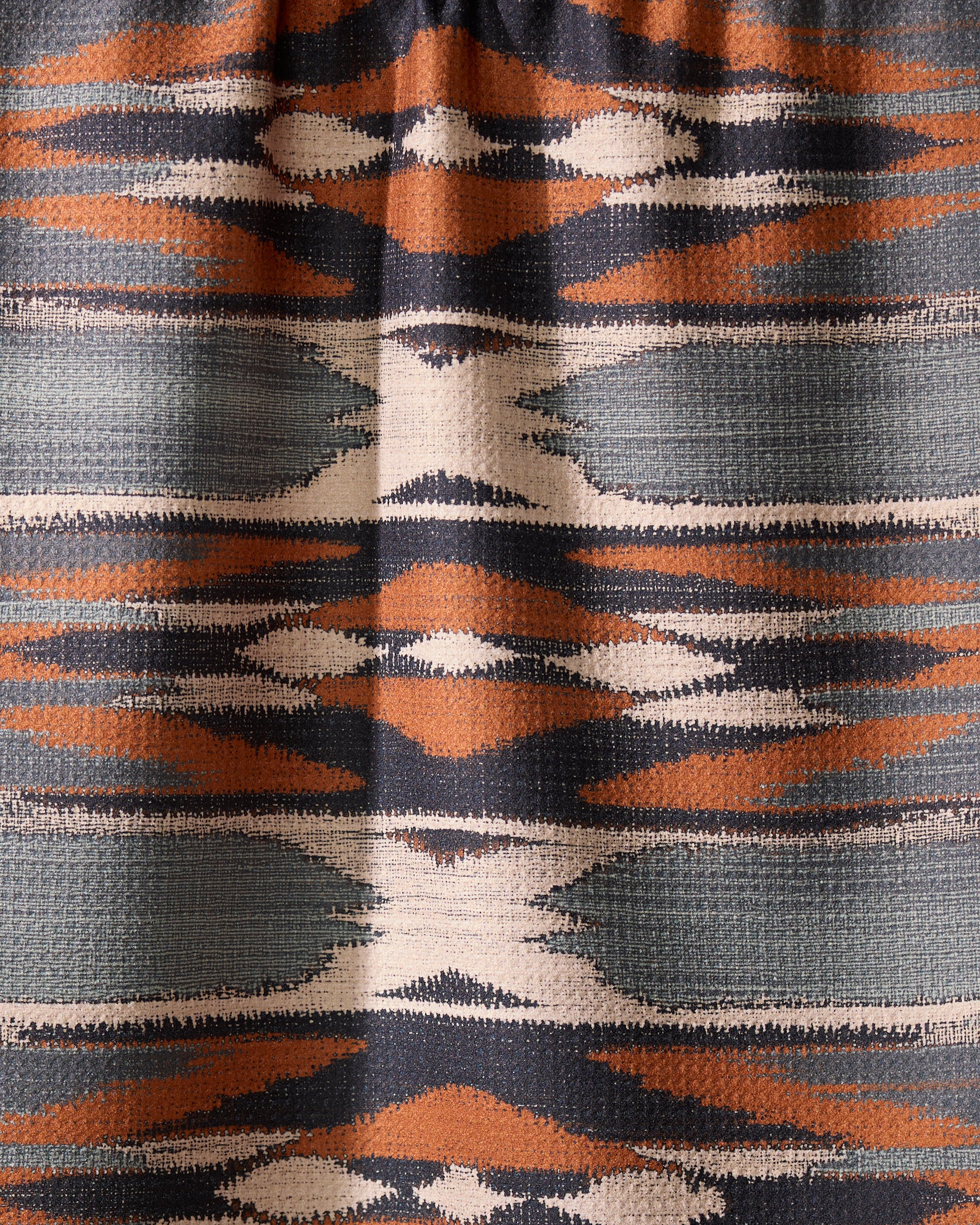 The Geometry Sedona tea towel features a geometric textile pattern with horizontal bands in orange, navy, white, and gray, showcasing symmetrical diamonds and zigzags—perfect for brightening your kitchen with its quick-drying design.