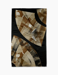 The Sepia Shift tea towel by Skye Walker features an abstract design with black, brown, beige, and tan tones. Overlapping shapes create a dynamic modern look on a black background—a stylish accent for any kitchen.