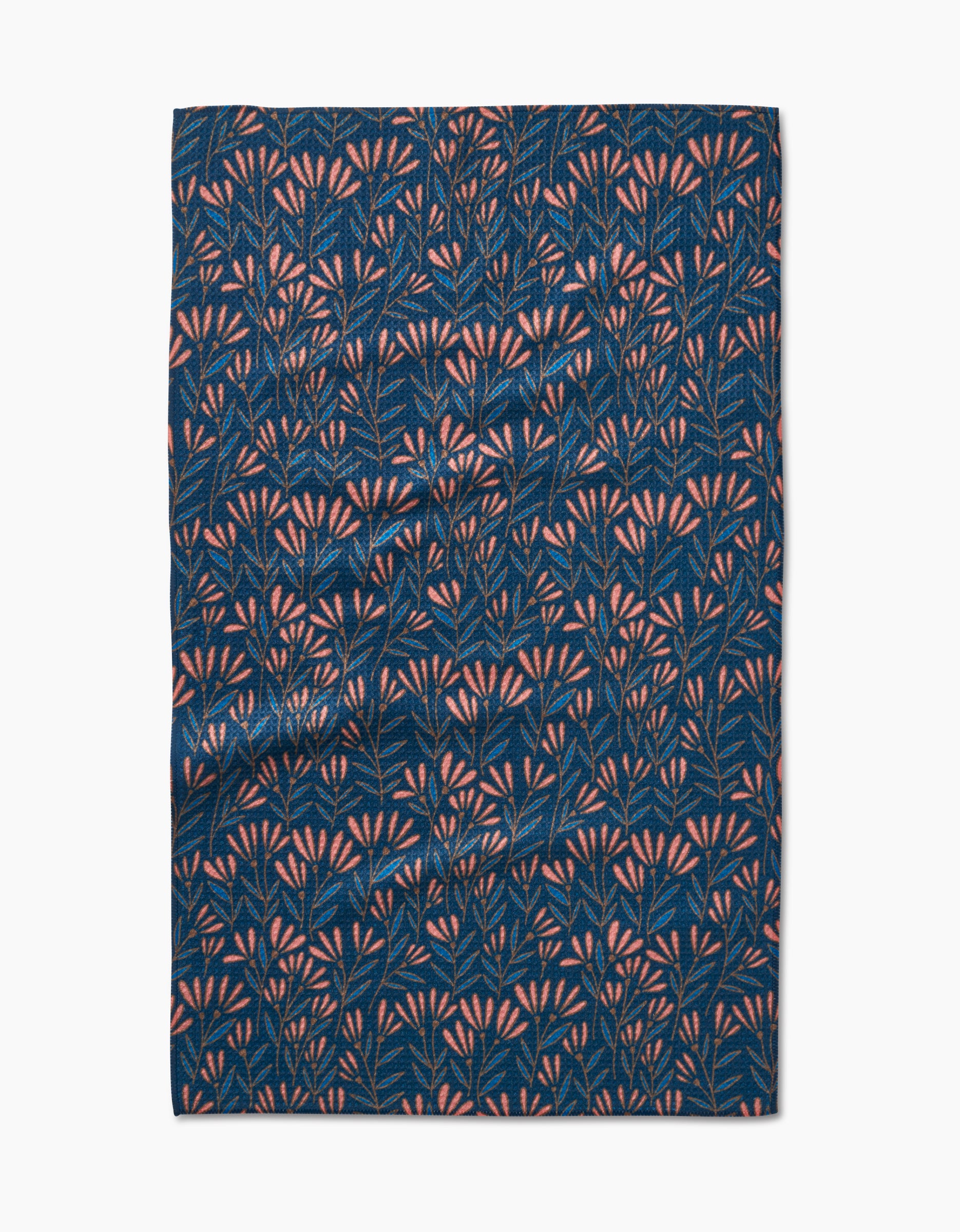 The Sirocco tea towel by Amy MacCready features dark blue Geoweave fabric with a dense pattern of small pink and light blue leafy branches. Ultra-absorbent, it is shown slightly wrinkled and laid flat on a white background.