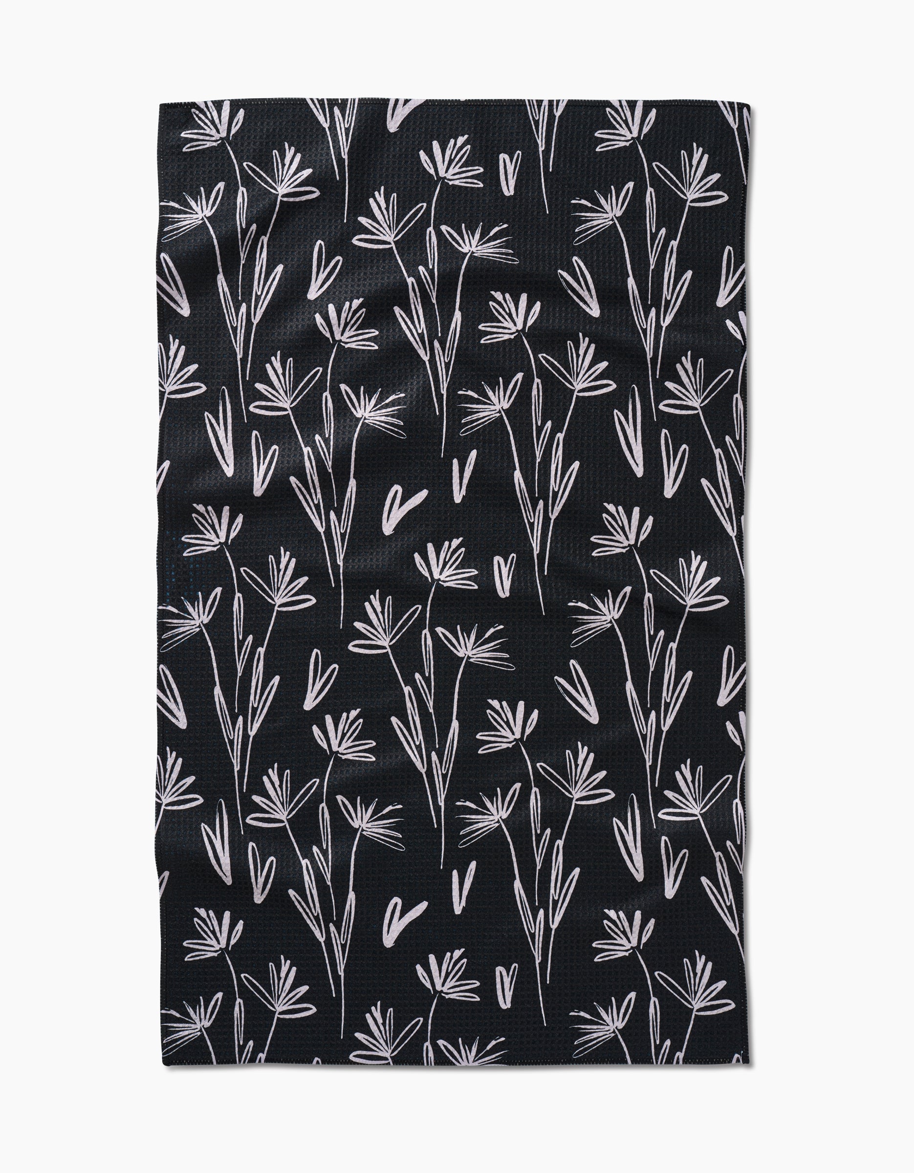 The Sketchbook Dust tea towel by Toboggan Avenue is black with a white hand-drawn floral and heart pattern in a scattered, repeating design. Made from durable, elegant Geoweave™ fabric.